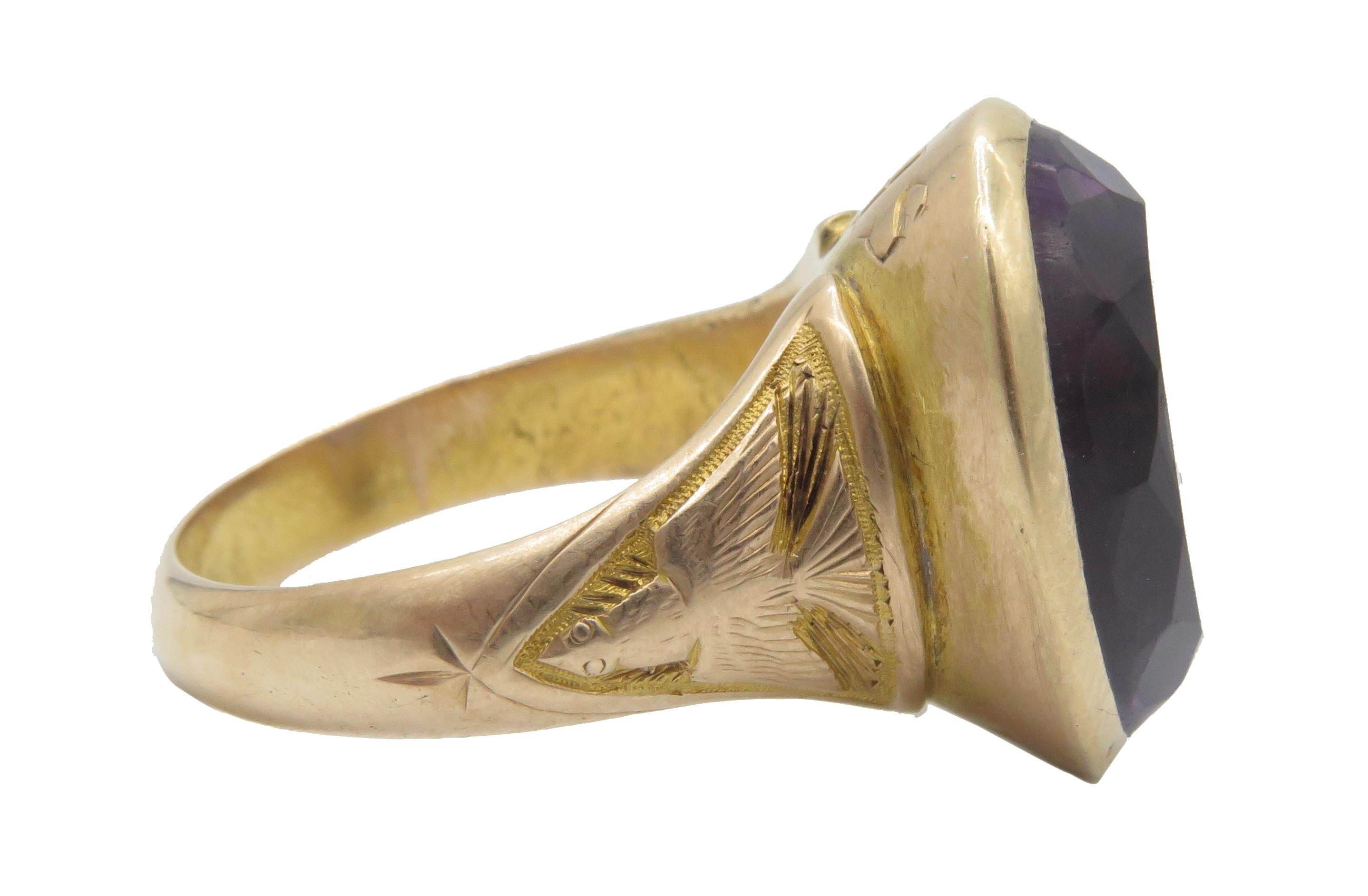 A beautiful, 18kt yellow gold Amethyst ring in a US size ring 11.  With a beautiful faceted Amethyst set in the center of the ring. This, beautiful ring has a cross engraved inside the shank and a cross below the amethyst in the top. In the bottom