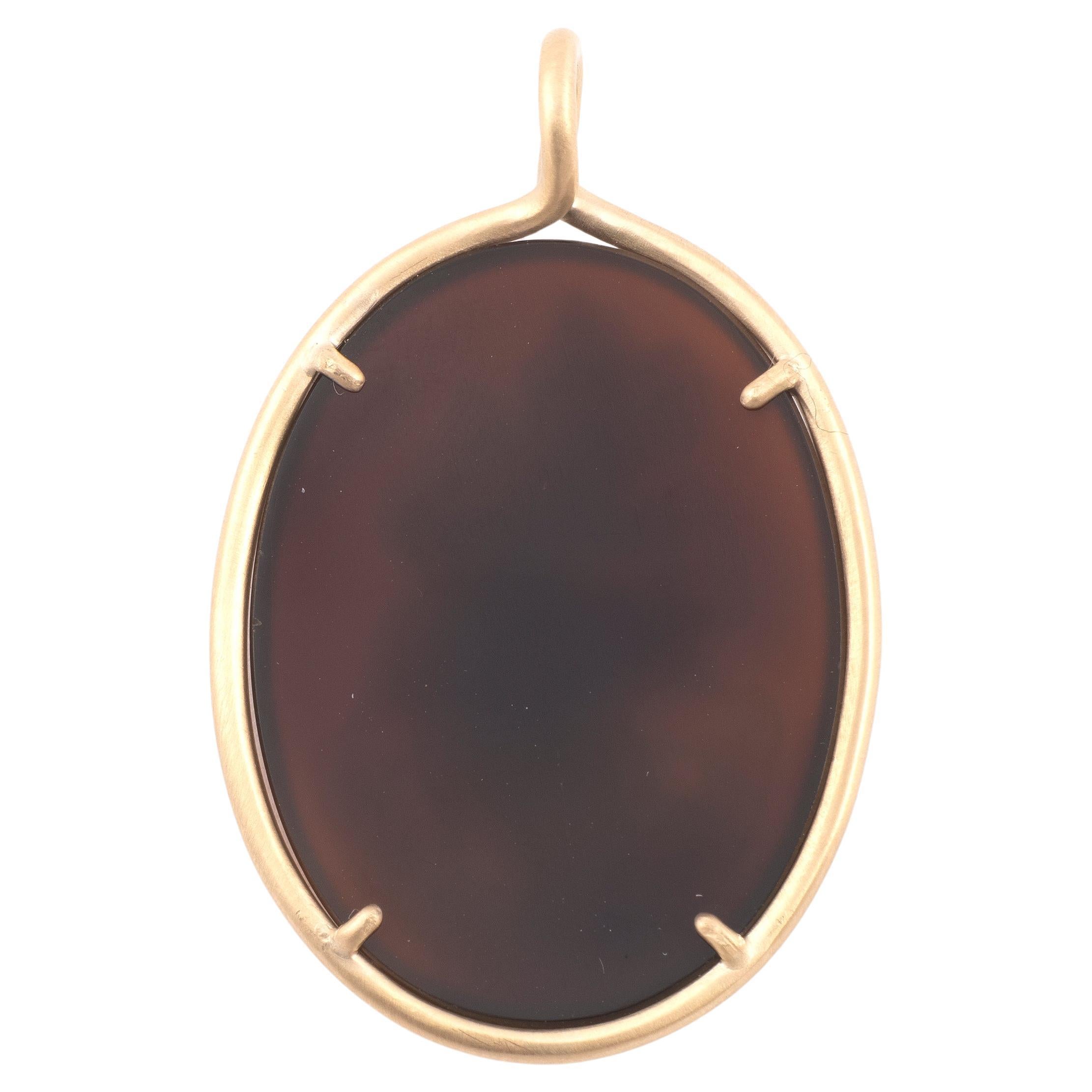 Cameo on agate depicting a woman carrying a jewellery box, her feet on clouds. 18kt yellow gold frame pendant. Size 41mm x 28mm Weight: 6.29gr.