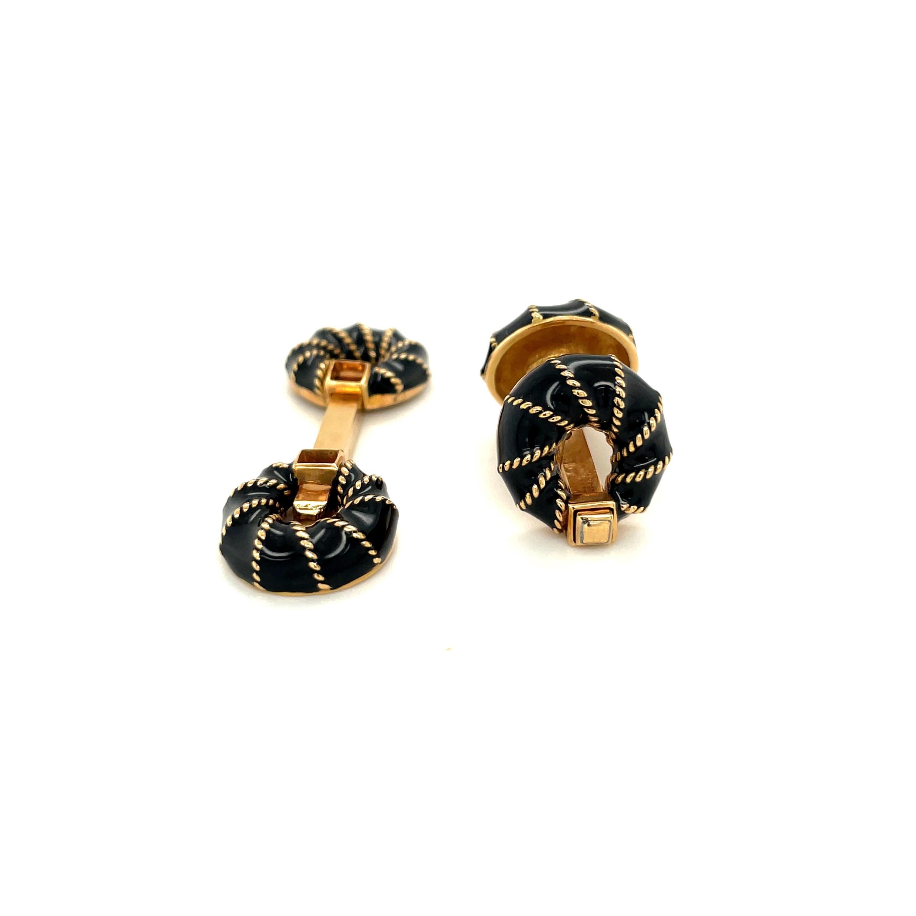 Classic 18 karat yellow gold cuff links. The bar style cuff links are designed with round donut shaped black onyx end pieces. The onyx is wrapped in gold. The bar style works with a spring mechanism.