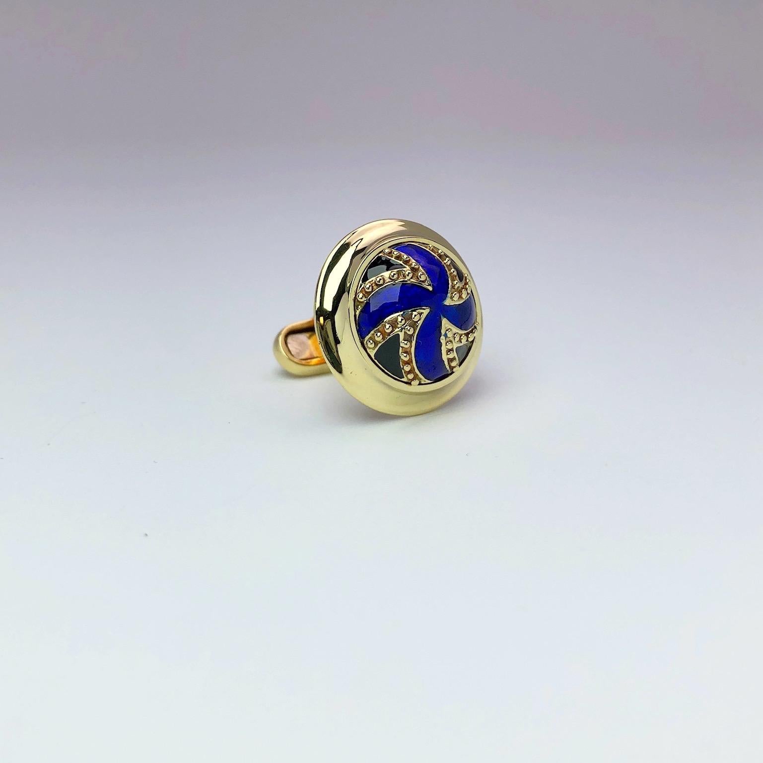Classic 18 karat yellow gold cufflinks. The center is enameled in a royal blue ,accented with beads of yellow gold. Cufflinks have a hinged bar back. Diameter is 29mm
Stamped 18K
