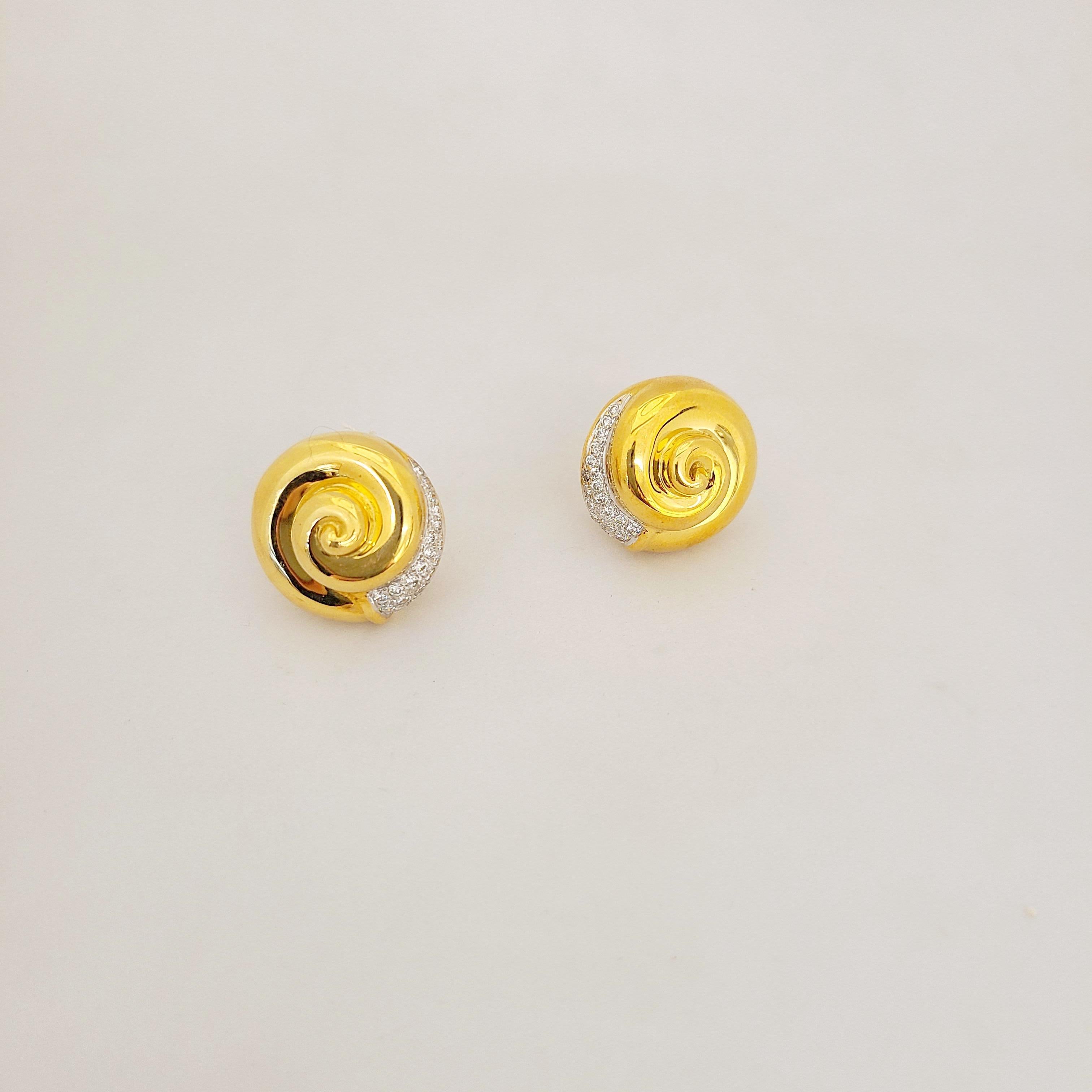 These 18 karat gold button earrings are designed in a high polished yellow gold swirl accented with round brilliant diamonds. The earrings measure 3/4
