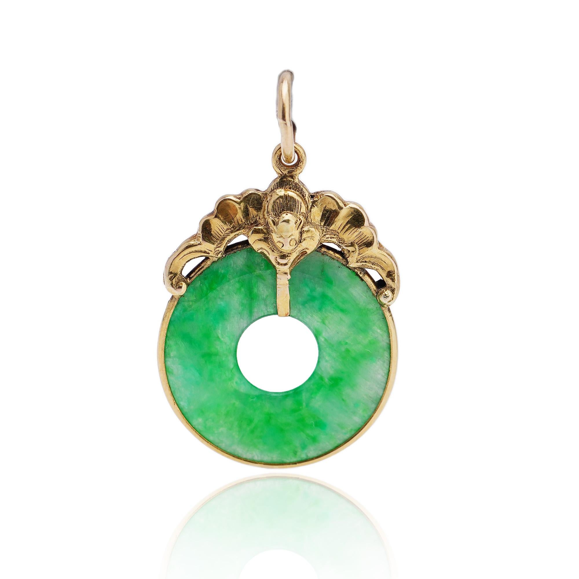 This is a beautiful vintage 18kt. yellow gold and donut circle jade pendant, it is mounted in 18kt. gold in a shape of a bat. 
Made in the 1950s, it is been tested positive for 18kt. gold. 

Dimensions -
3.2 x 1.9 x 0.1 cm 
Weight: 3.05