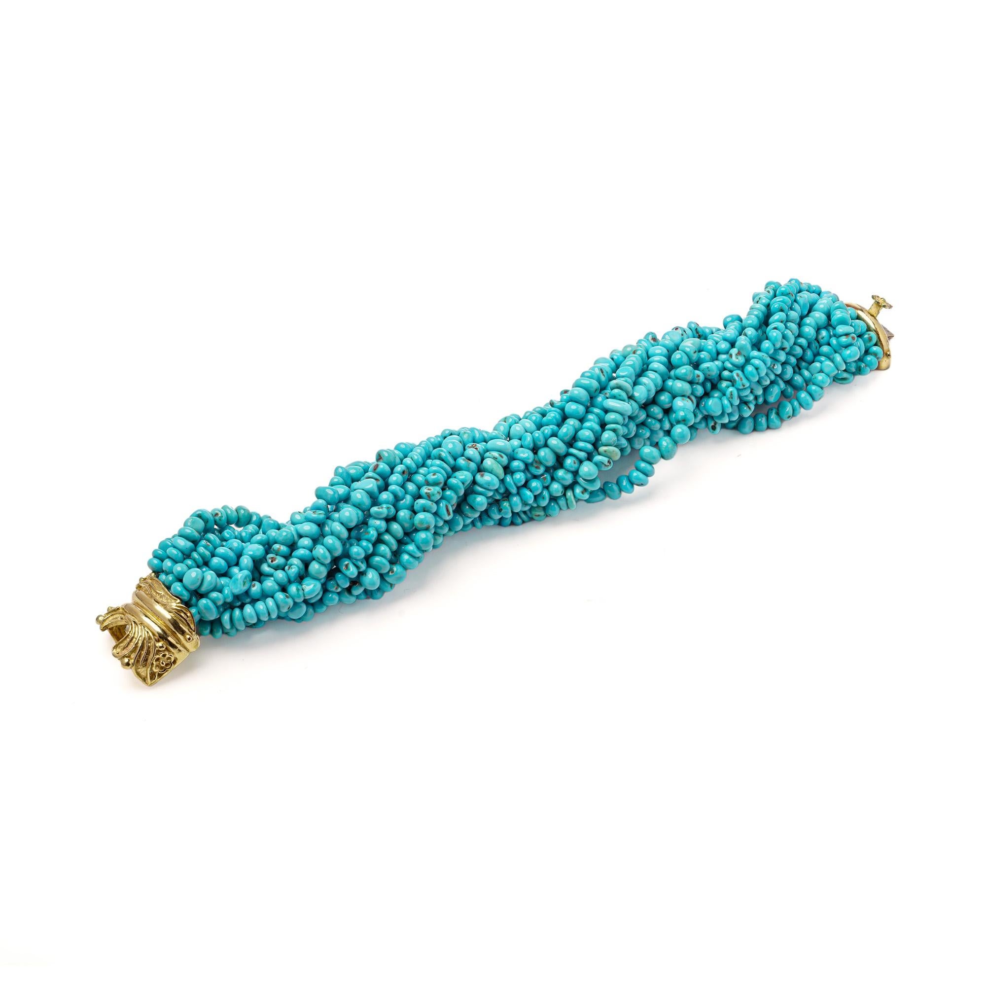 Un bracelet italien vibrant et substantiel composé de multiples brins de perles de turquoise naturelle polie mesurant environ 5-7 mm . Le bracelet est doté d'un fermoir sculptural en or jaune 18 carats, orné d'arêtes et de volutes, estampillé de