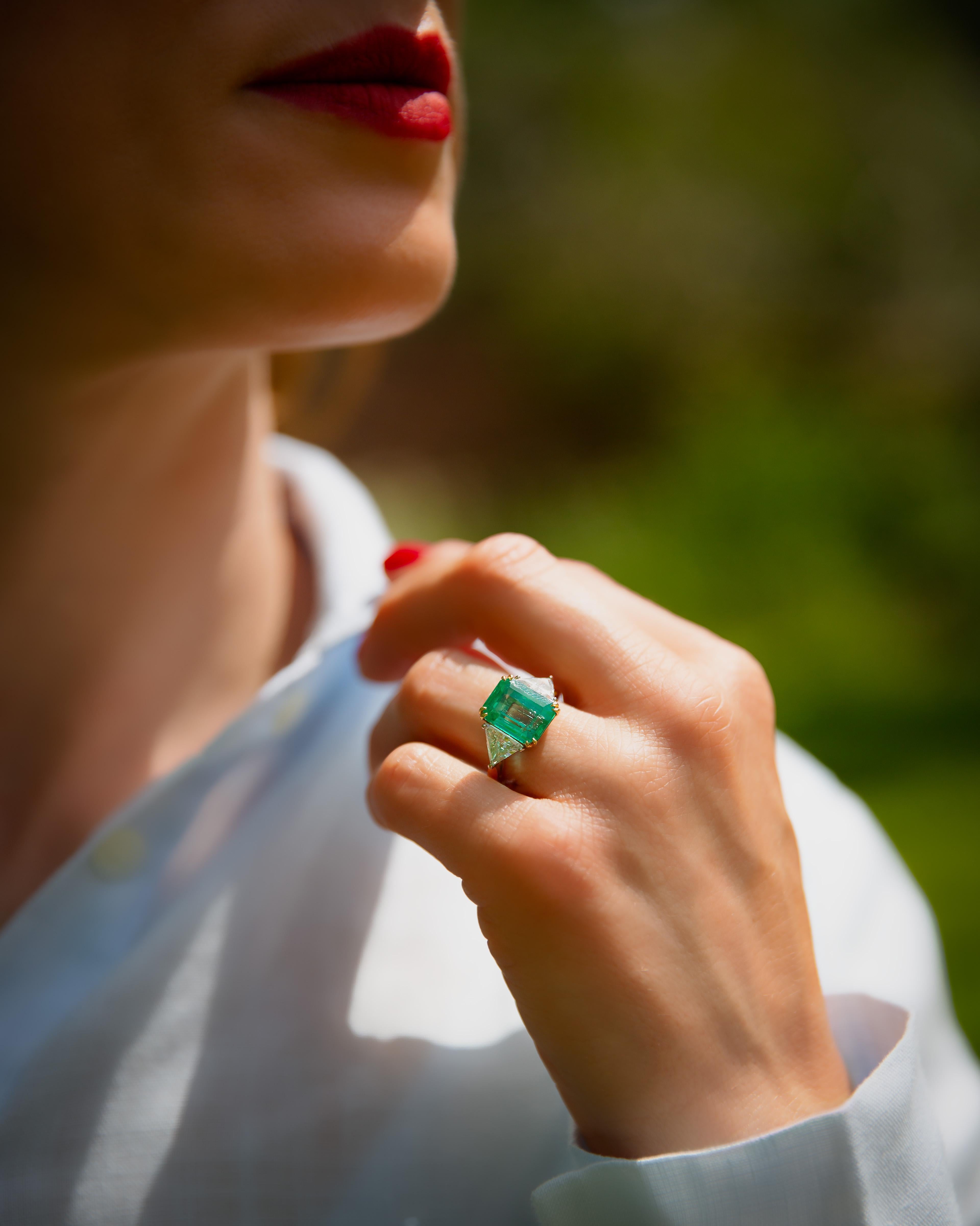 Ti presentiamo il nostro squisito anello con tre pietre di smeraldo e diamanti in oro giallo 18 carati e platino, realizzato verso la fine degli anni '90. Questo gioiello con marchio di garanzia presenta un design senza tempo, contrassegnato da un