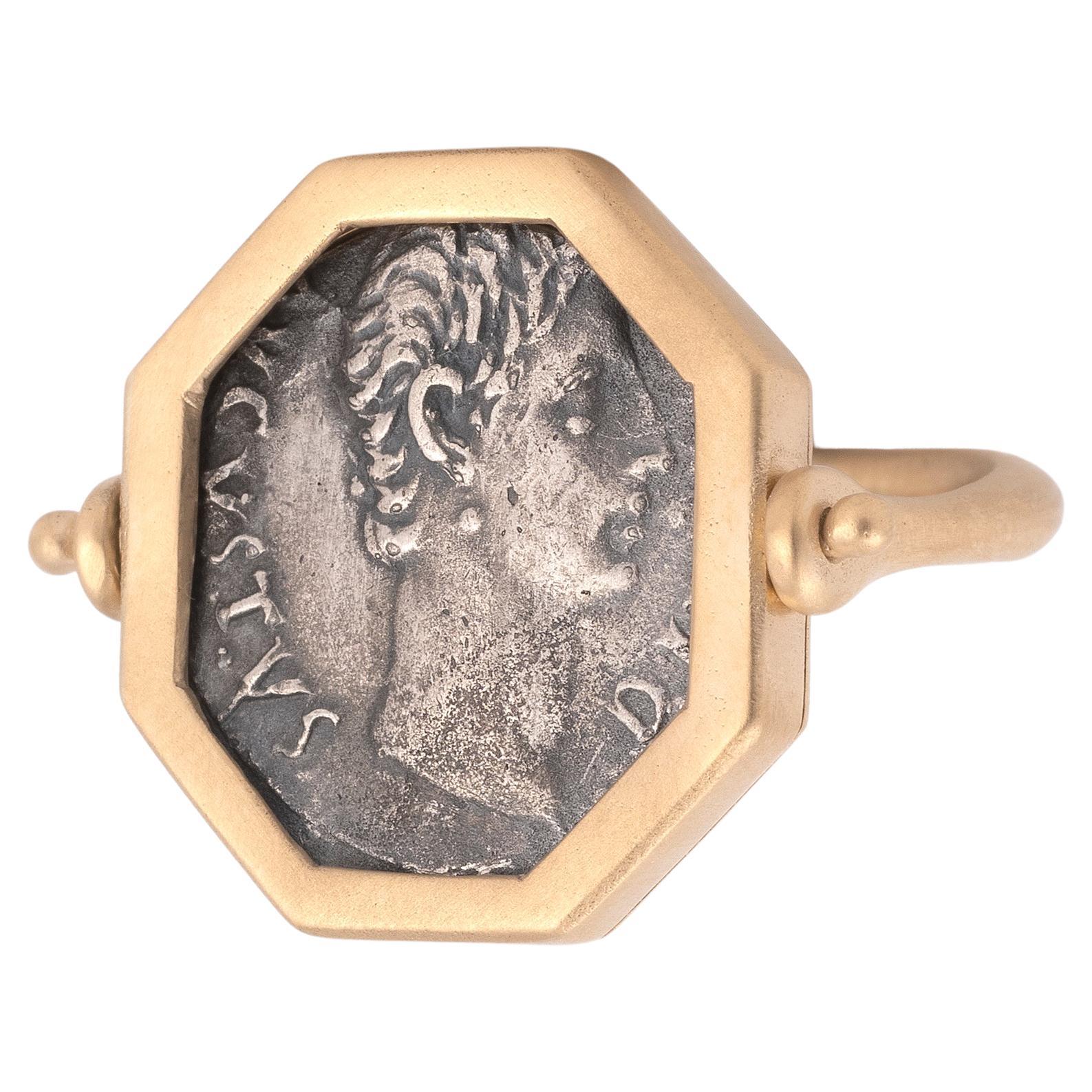 RING in 18kt yellow gold  with a pivoting octagonal bezel, set with a roman silver coin
AUGUSTO. Denario. Lugdunum (15-13 a.C.). R/ Toro a der.; IMP. X. FFC-108. SB-137.
18kt brushed gold.
Size : 7
Weight: 10,23gr.