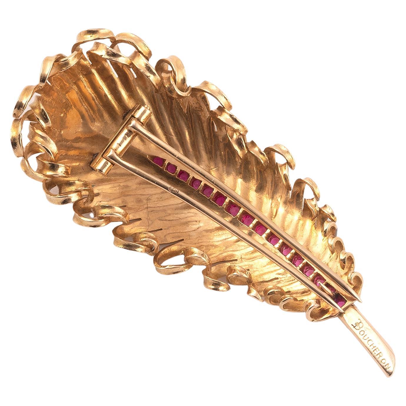 Yellow gold feather brooch finished with rubies, approx. g 20.52, length cm. approximately 6.80 cm. Signed Boucheron and French assay marks.