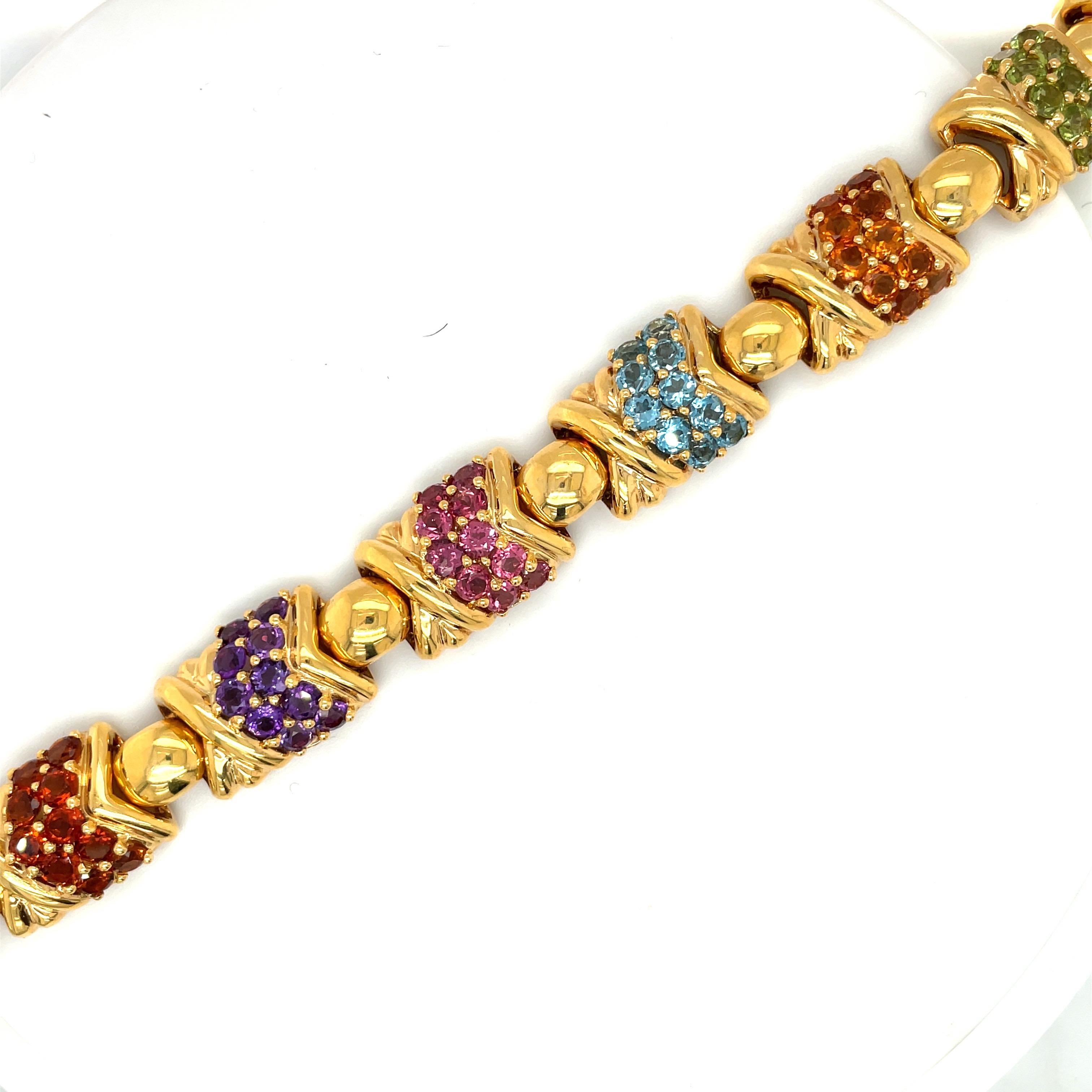 This colorful 18 karat yellow gold and semi precious stone bracelet is designed with 6 sections composed of semi-precious stones and a gold 