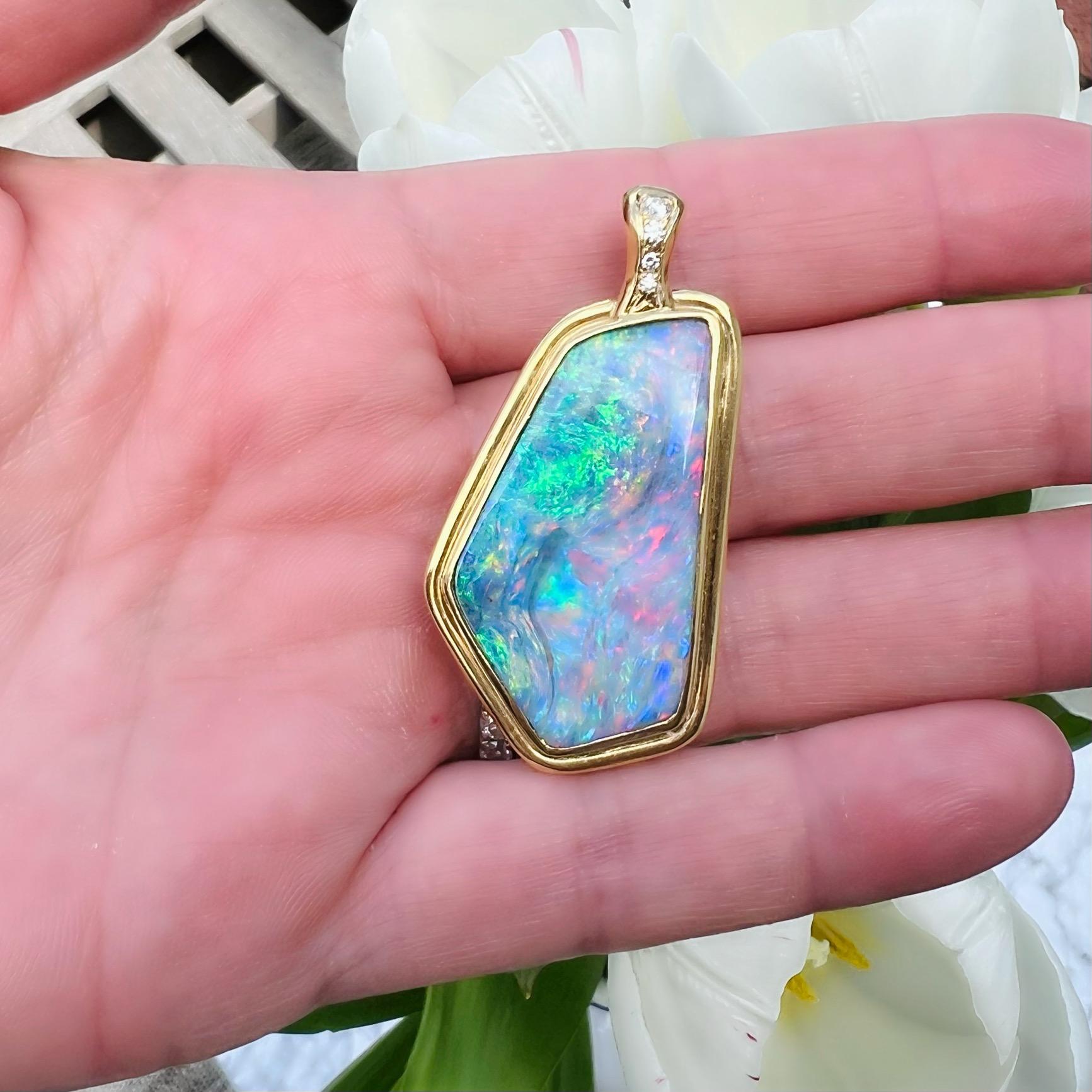 Farbblitze, die Ihnen den Atem rauben! Dieser Anhänger aus 18-karätigem Gelbgold ist mit einem atemberaubenden australischen Boulder-Opal besetzt, der unglaubliche rosa, grüne, lavendelfarbene und blaue Farbtupfer aufweist. Der Ballen des Anhängers