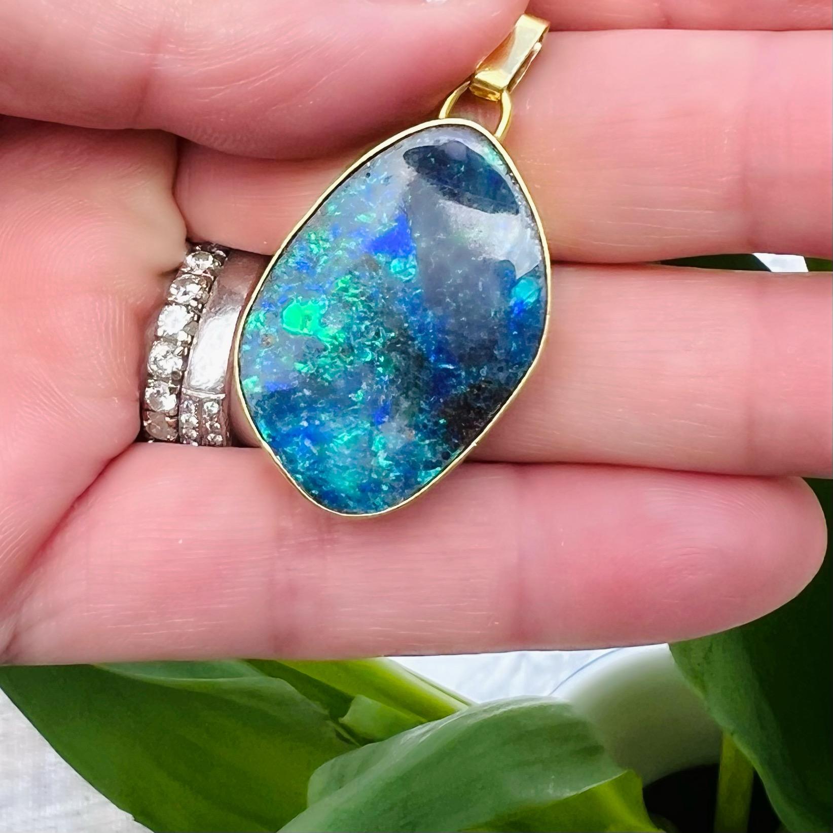 It's hard to imagine that such natural beauty comes from our earth. This 18 karat yellow gold pendant features an organic wavy Australian boulder opal (weighing approximately 4 carats) set in a design that outlines the natural curved edges of this