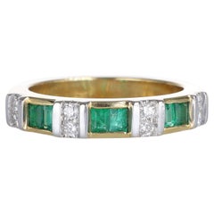 Anello a fascia in oro giallo 18kt con alternanza di smeraldi e diamanti Carrs-Cut