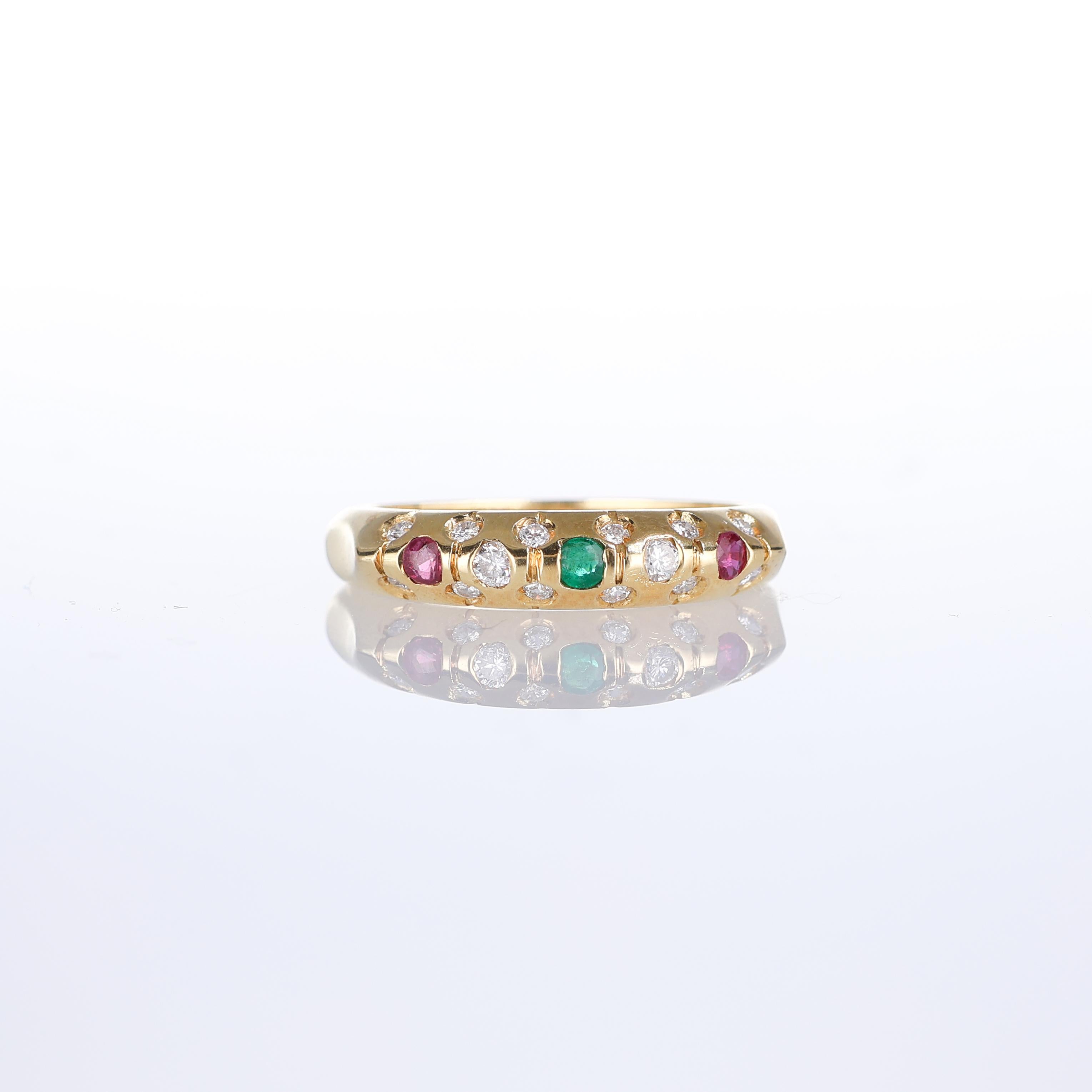This elegant 18kt yellow gold band ring showcases a vibrant interplay of gemstones. Featuring rich green emeralds (0.04 carats total), deep red rubies (0.08 carats total), and sparkling white diamonds (0.28 carats total), the ring radiates timeless