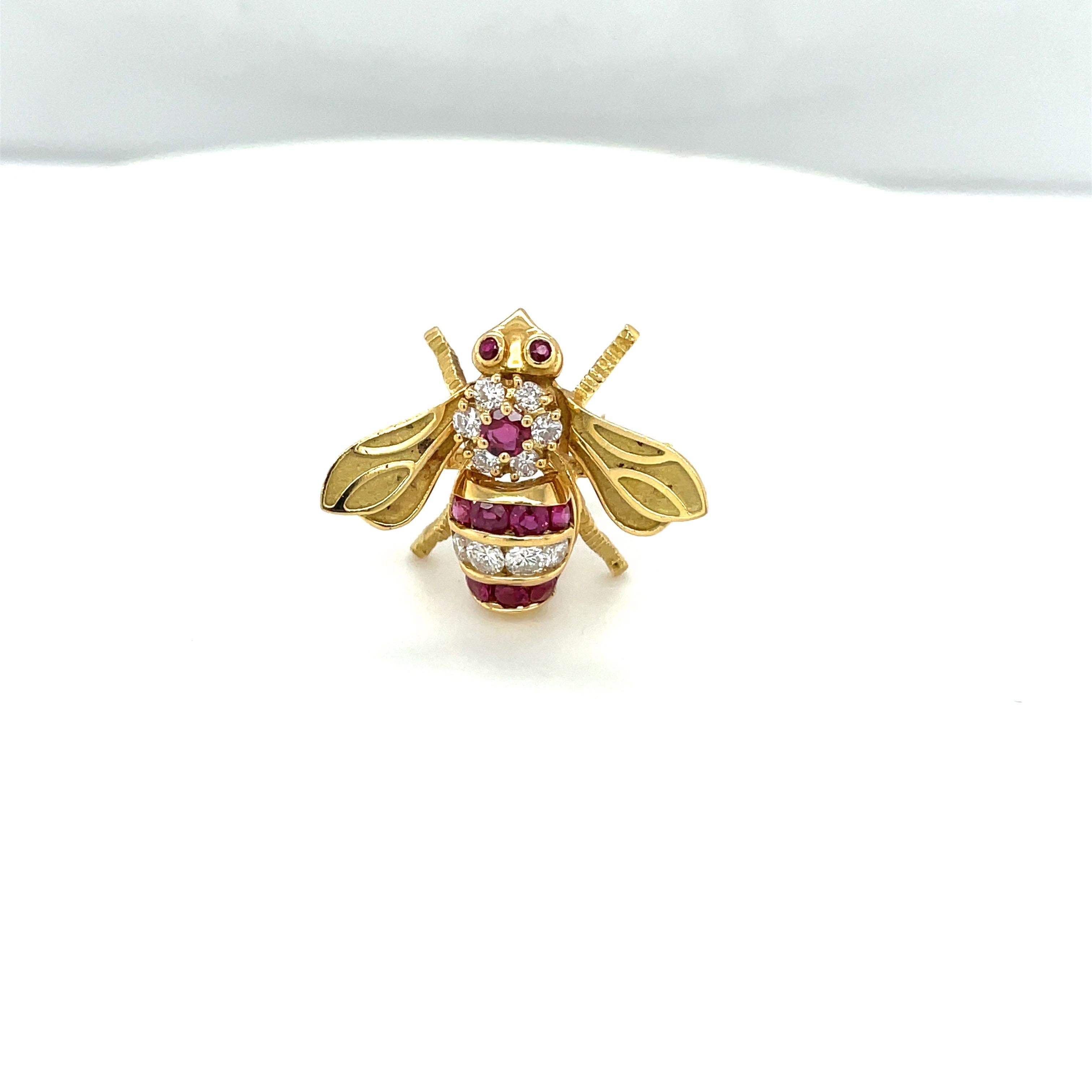 Classic 18 karat yellow gold bee brooch. This little bee is beautifully set with round brilliant diamonds and rubies. The wings are finished in a matte gold with shiny detail. The bee measures approximately 1/2