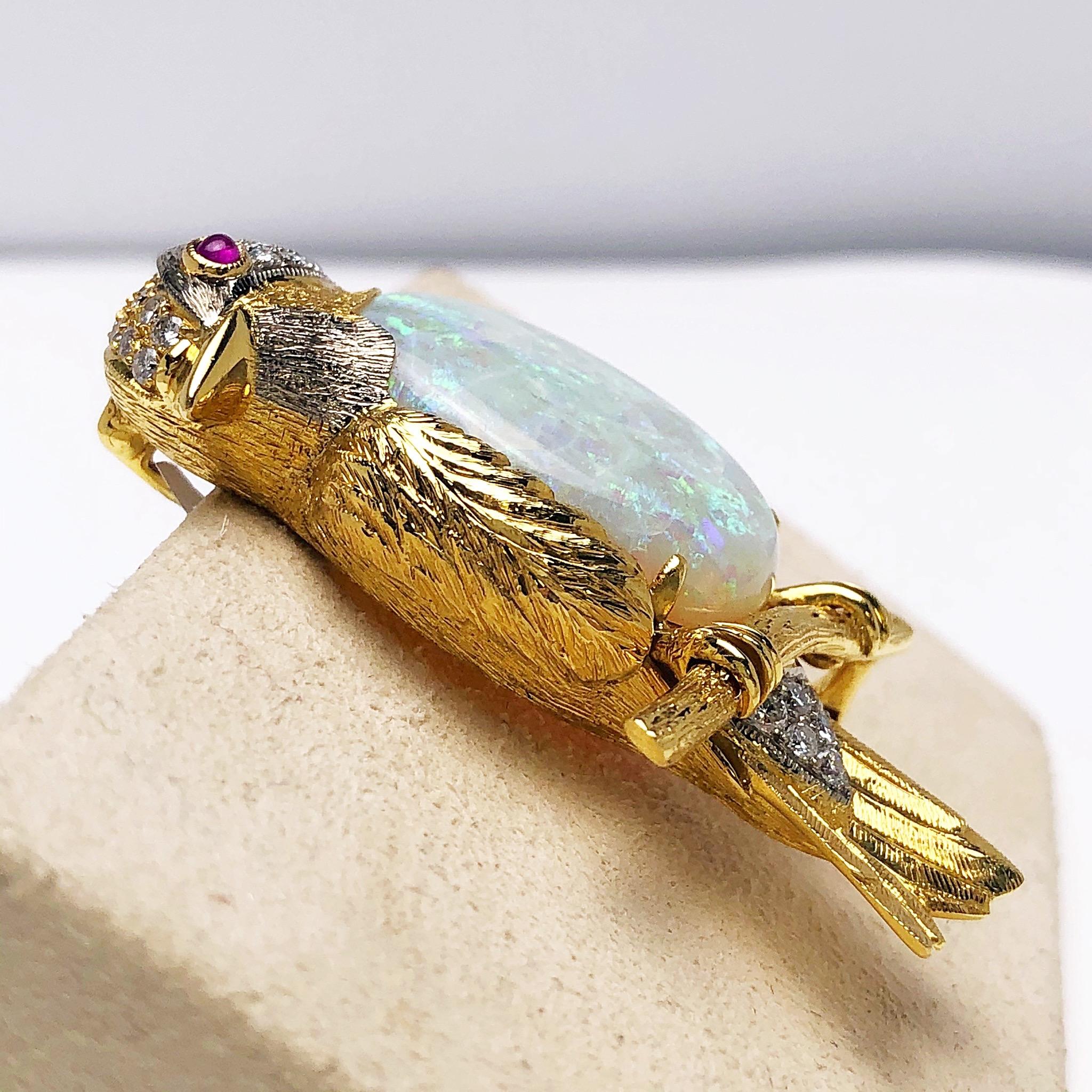 This lovely vintage bird brooch is crafted in 18 karat yellow gold with small touches of white gold. The belly of the bird is set with a magnificent white opal weighing 11.26 carats. This precious opal has flashes of green.  The birds head and part