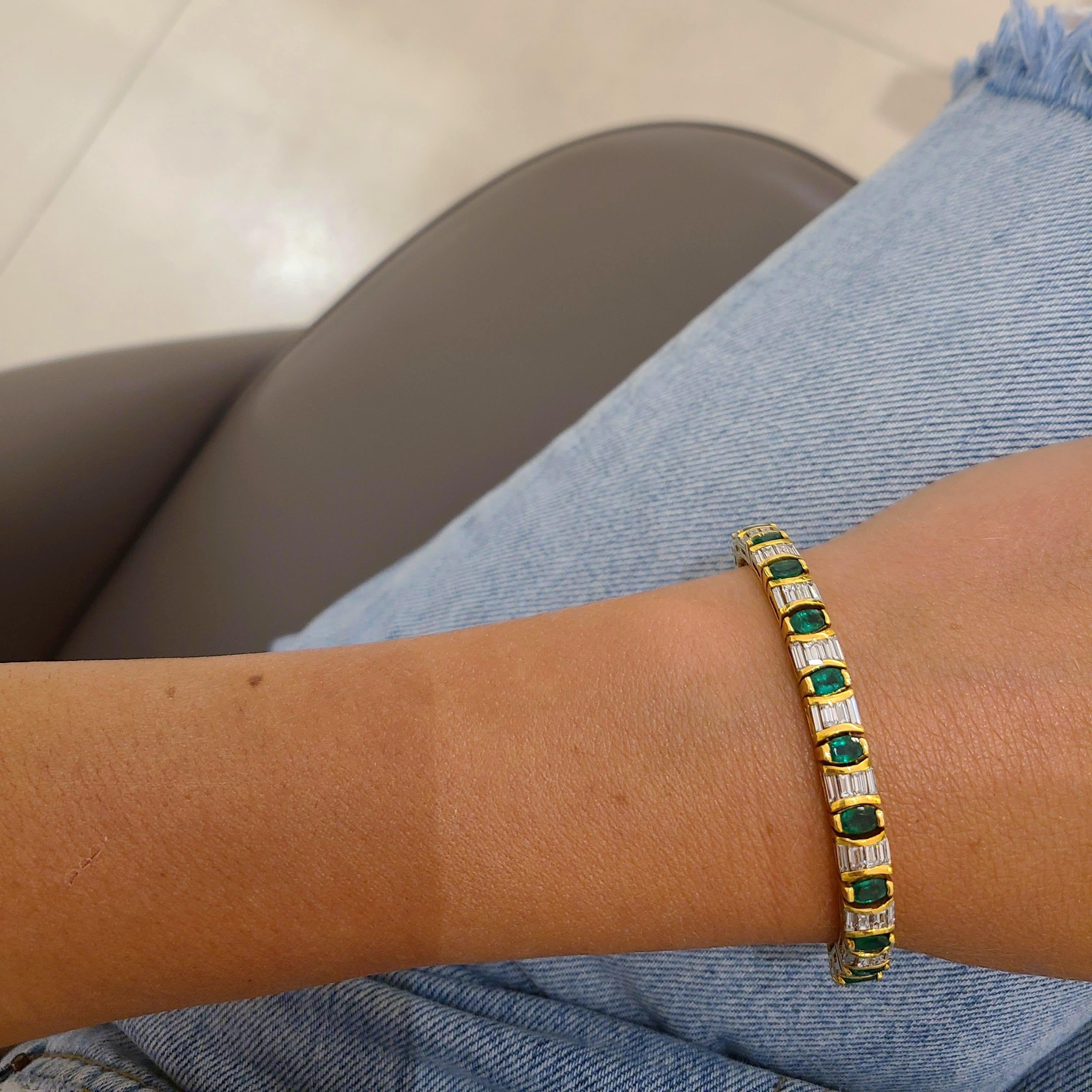 An 18 karat yellow gold line bracelet designed with 22 Oval Emeralds and 88 Baguette Diamonds. Each Emerald is set in a gold bezel. The bracelet measures 7