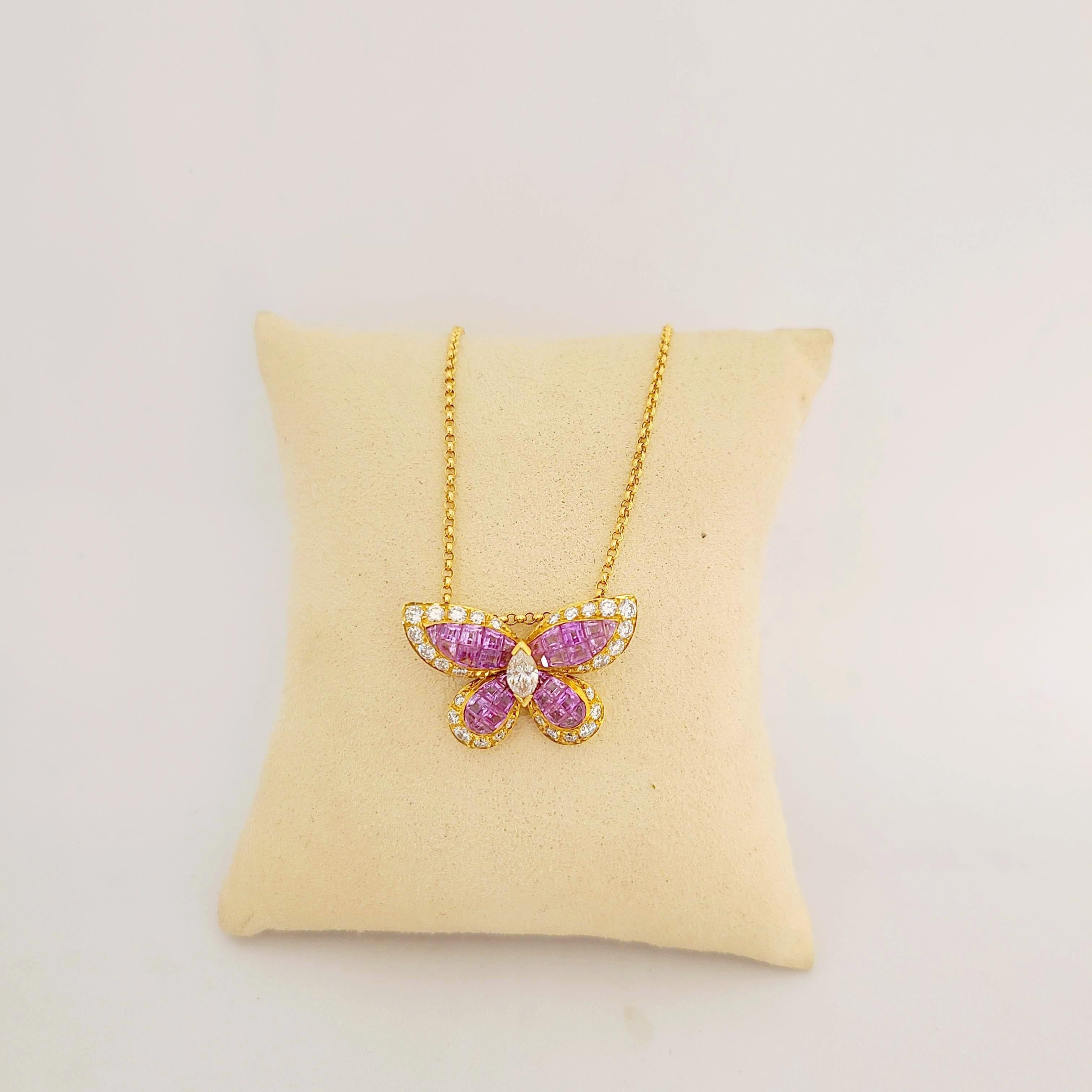 Beautiful  18 karat yellow gold butterfly pendant. The butterfly is invisibly set with square cut pink sapphires and outlined with round brilliant diamonds. The center is set with a single marquise diamond. The butterfly measures 1 1/8