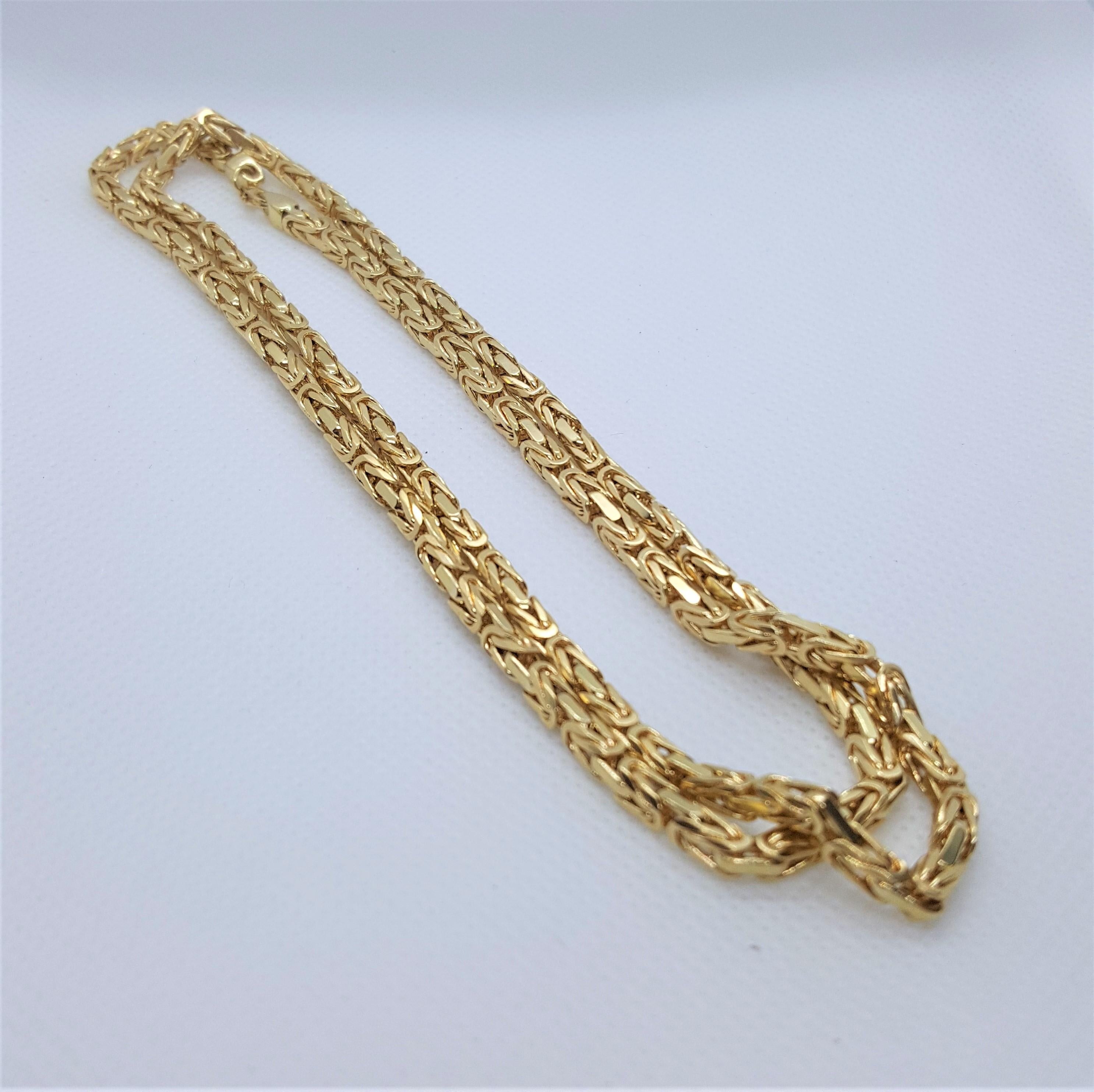 A well-made 26-inch byzantine link chain that's 18kt yellow gold, 3.1mm square, stamped 750 18K and weighs 56.6 grams, and secured with a lobster clasp, and the links are solid. This chain is in very nice condition. It's pictured on a woman;