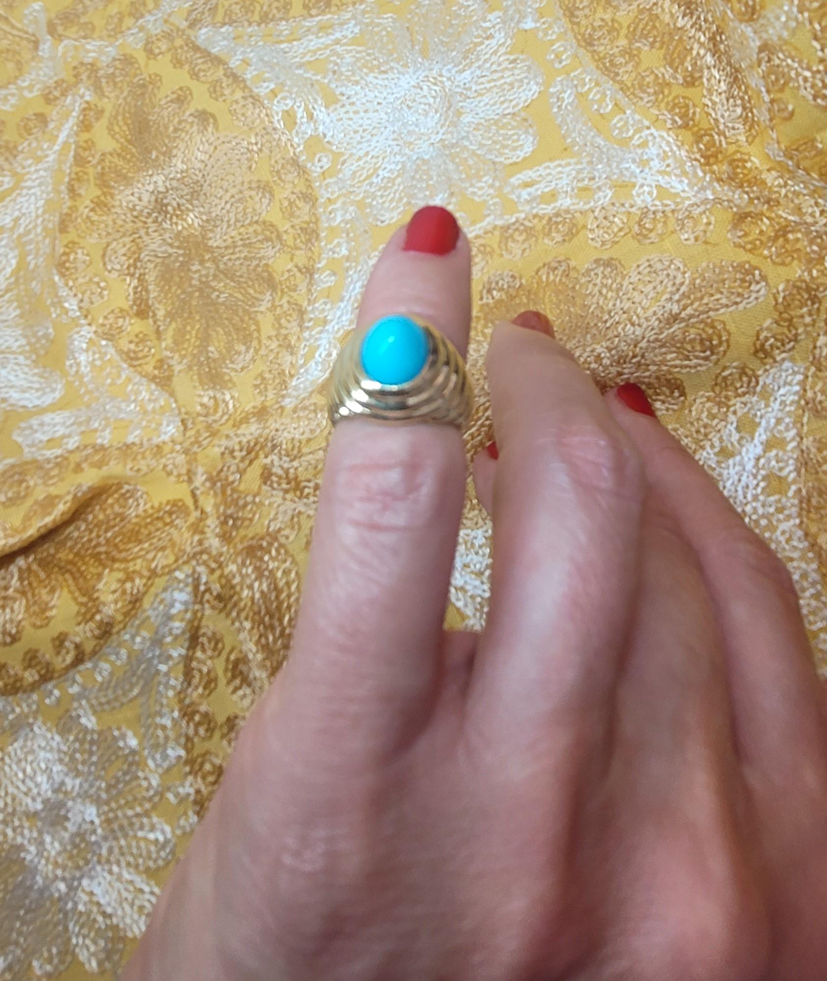This is an 18kt yellow gold pinky ring featuring a domed cabochon blue turquoise stone set in a ribbed bezel dome. The ring weighs 10.9 grams, with a 9mm x 7.2mm stone and a total width of 12.6mm tapering to 5.7mm. It is stamped as 18kt gold. This