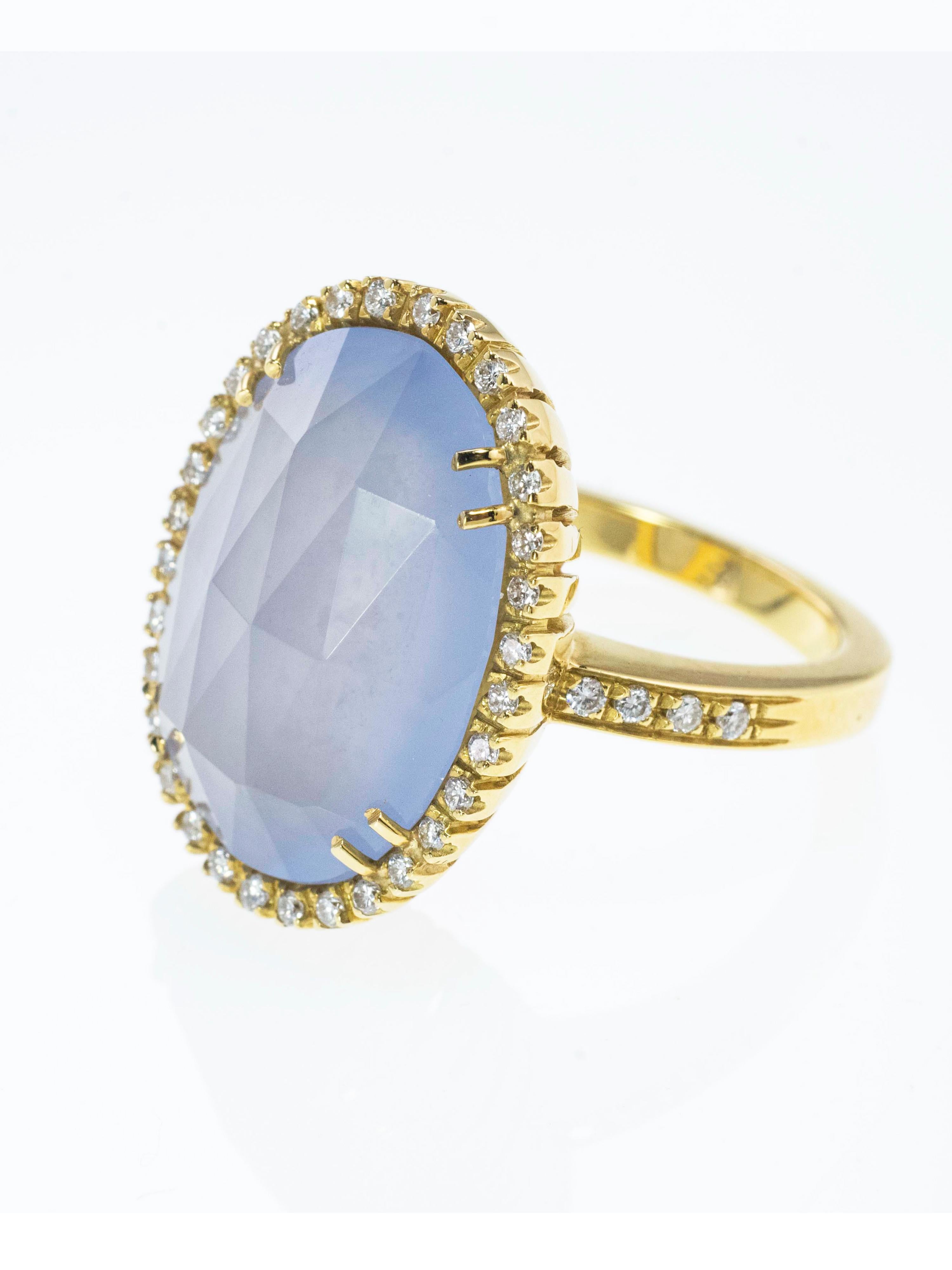 A solid 18 Kt yellow gold ring with a very elegant and classic design.
The faceted central Chalcedony has a beautiful light blue and purple color. 
It's enhanced by a Diamonds frame. these are also placed  on the ring shank and weigh in total ct