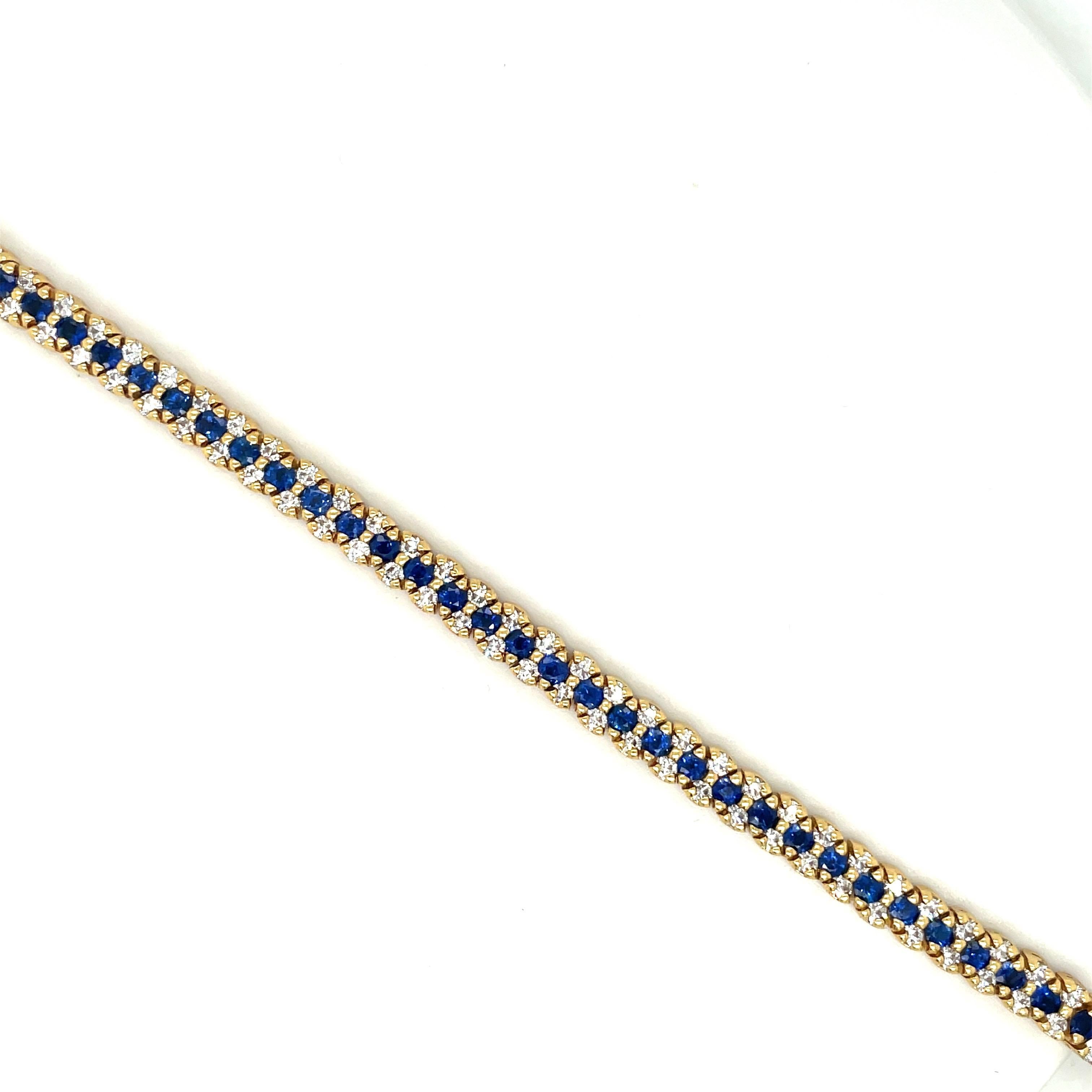 18 karat yellow gold tennis bracelet. This bracelet is designed with a center row of round brilliant cut blue sapphires and two rows of round brilliant cut diamonds. This is a timeless and classic bracelet. The bracelet measures 7