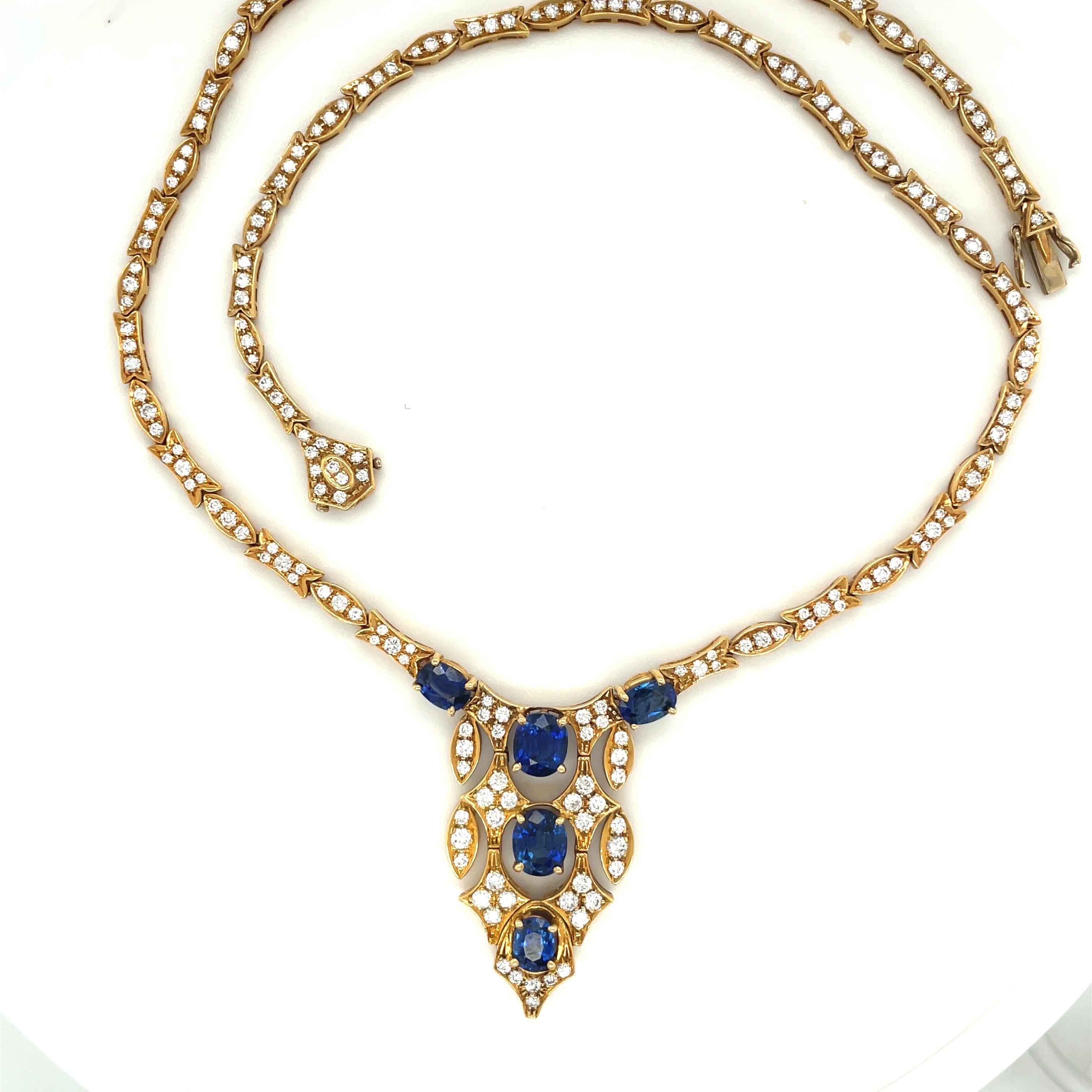 Classically designed 18 karat yellow gold necklace. The centerpiece of this necklace is set with 5 oval blue sapphires. The sapphires are accented with round diamonds set in marquise and diamond shaped links which continue to form the chain of the