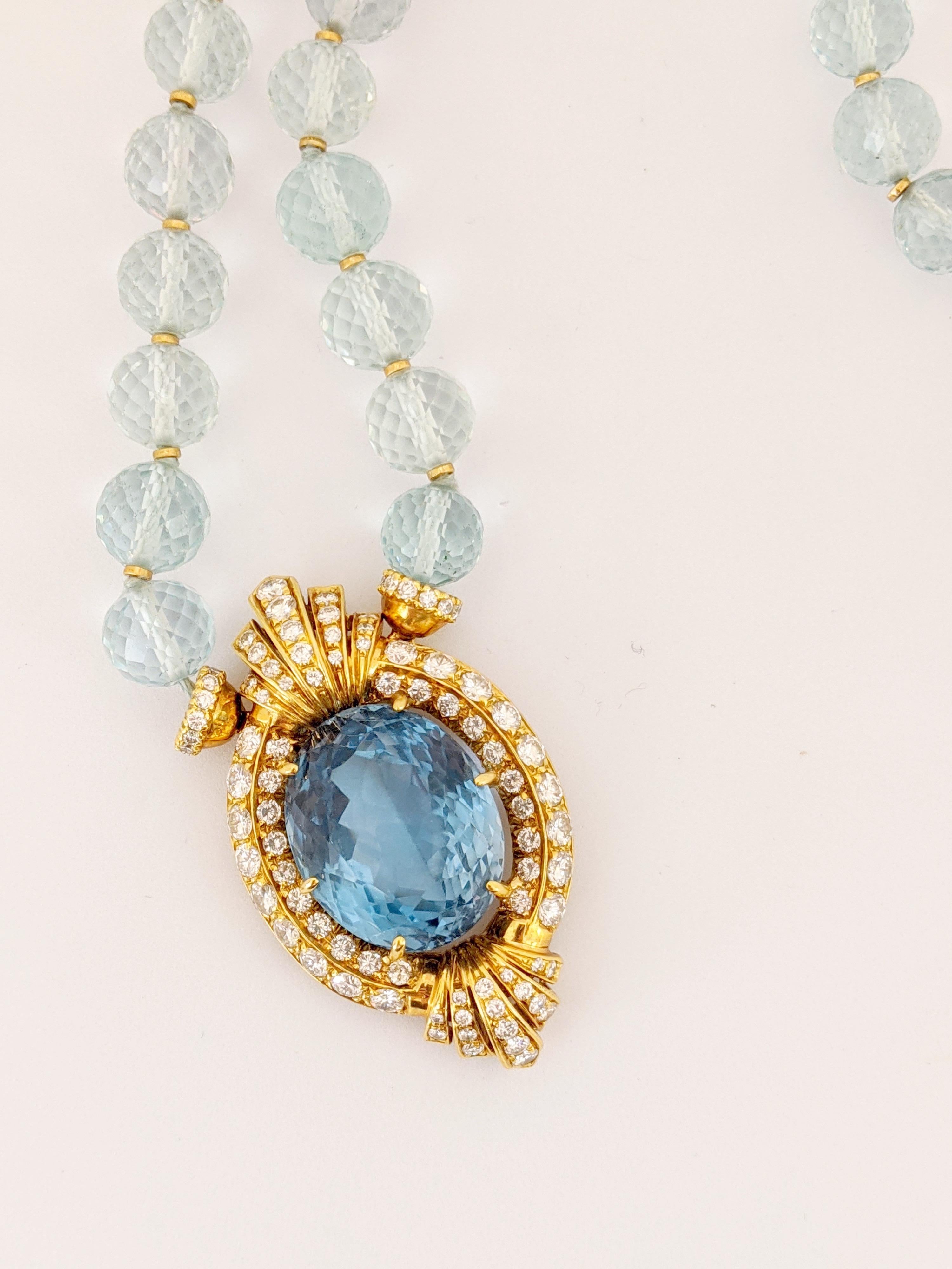 This majestic necklace features a showstopping  43.50 carat Oval Blue Topaz set in an elaborate 18 karat yellow gold and Diamond setting. The pendant is set on a strand of natural colored Aquamarine beads. The faceted beads are spaced with 18 karat