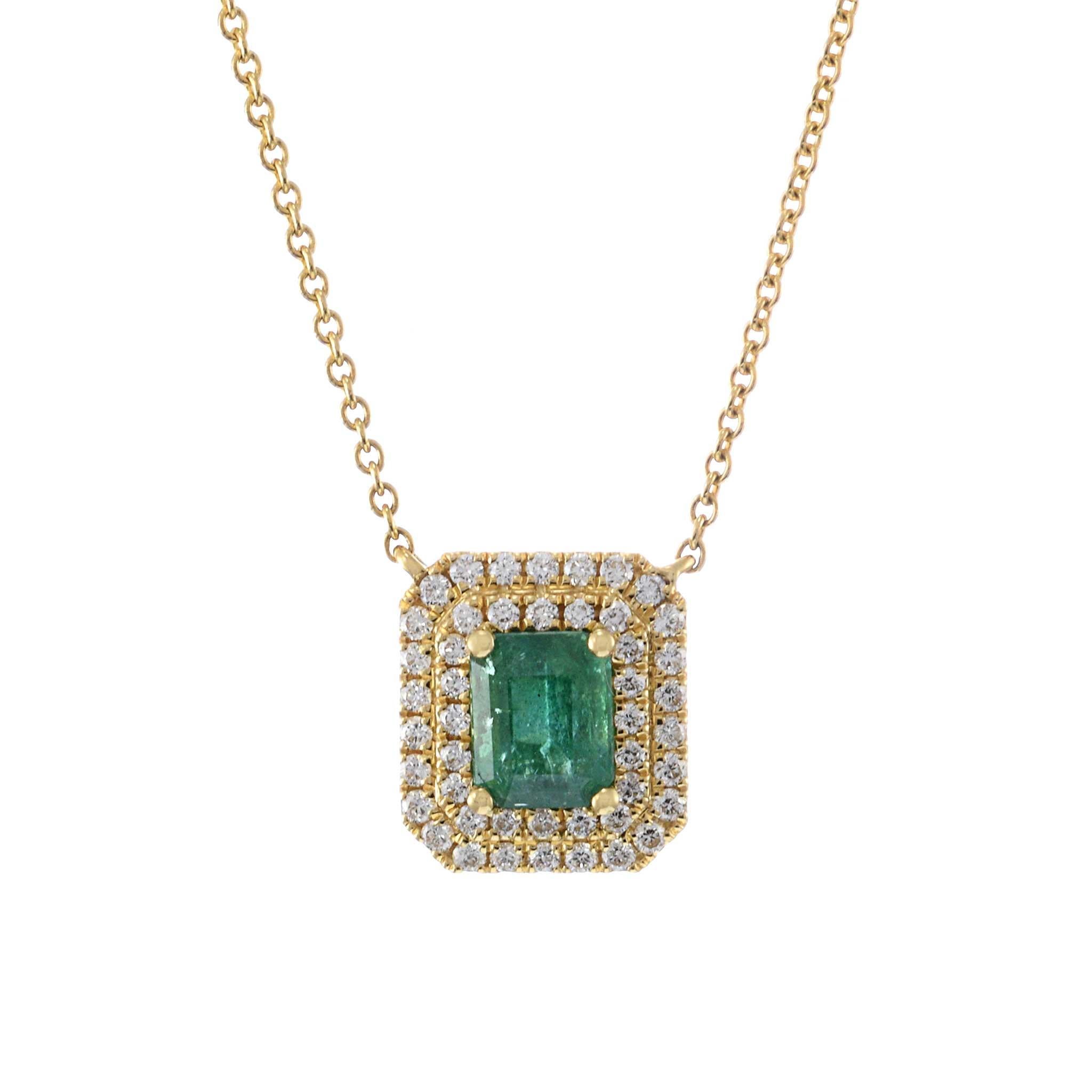 Questa squisita collana presenta uno smeraldo da 0,63 carati, incastonato in oro giallo 18KT. Il vibrante smeraldo è splendidamente circondato da una doppia aureola di diamanti taglio rotondo, per un totale di 0,28 carati. Questo lussuoso design