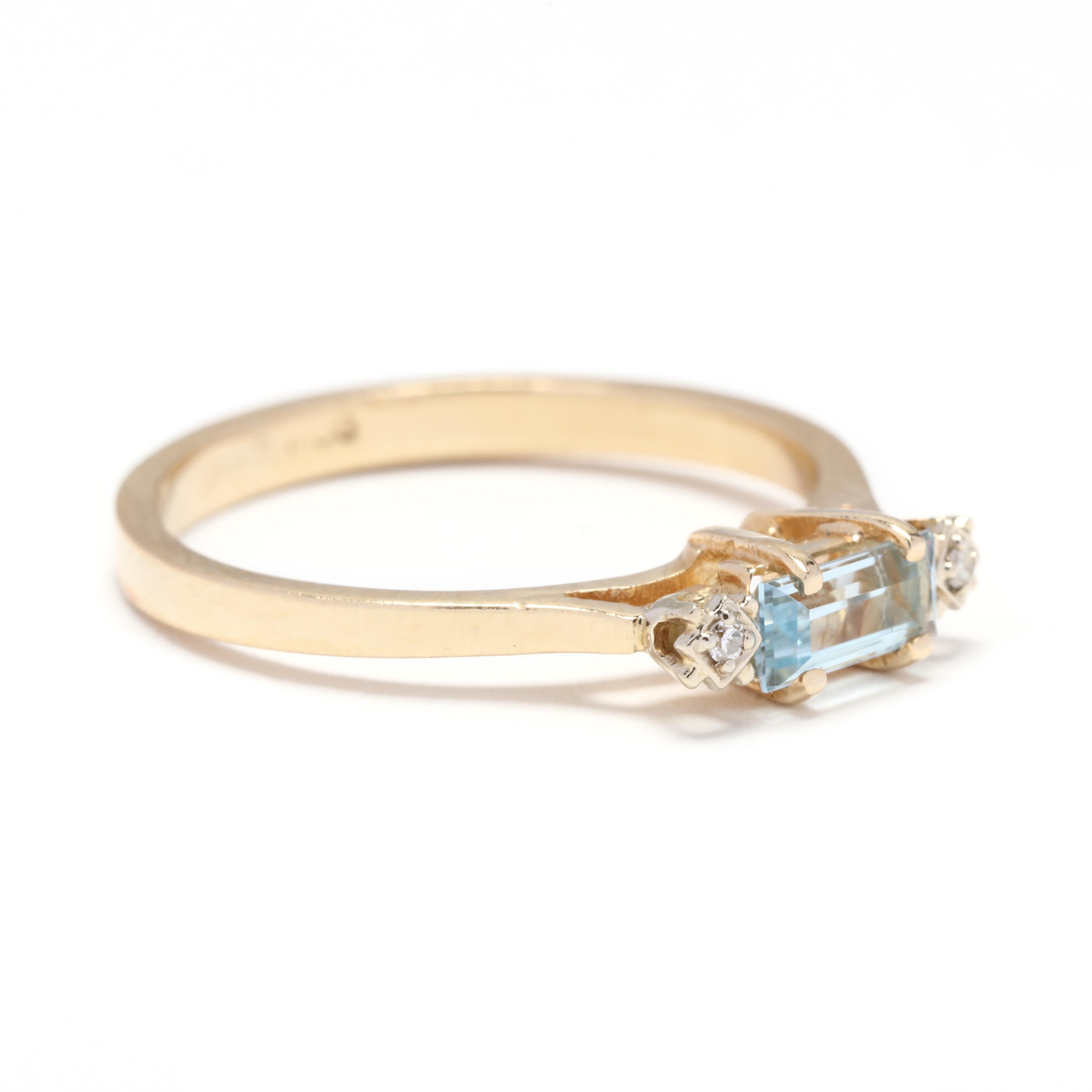 An 18 karat yellow gold, emerald cut blue topaz and diamond band ring. A horizontal ring with a prong set, emerald cut blue topaz weighing approximately .35 carat with a diamond on either side and a tapered band.

Stones:
- blue topaz, 1 stone
-