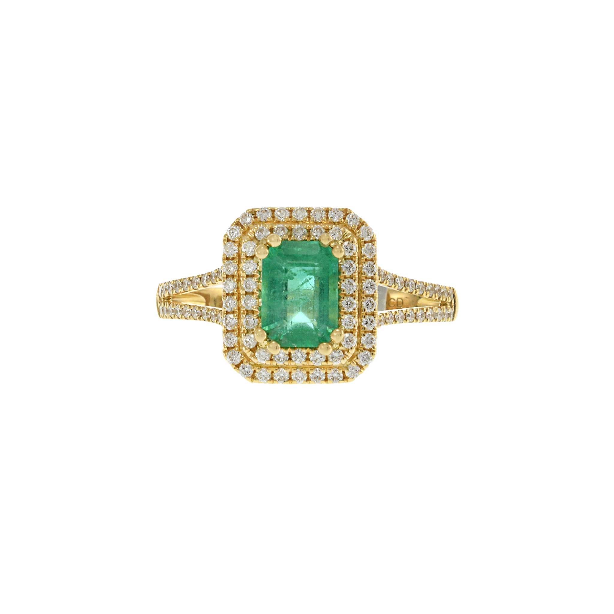 This stunning ring features a 0.84 carat emerald cut emerald at the center, beautifully set in 18KT yellow gold. The emerald is surrounded by a double halo of 0.38 carats of round cut diamonds with G-H color and VS1-VS2 clarity, enhancing its