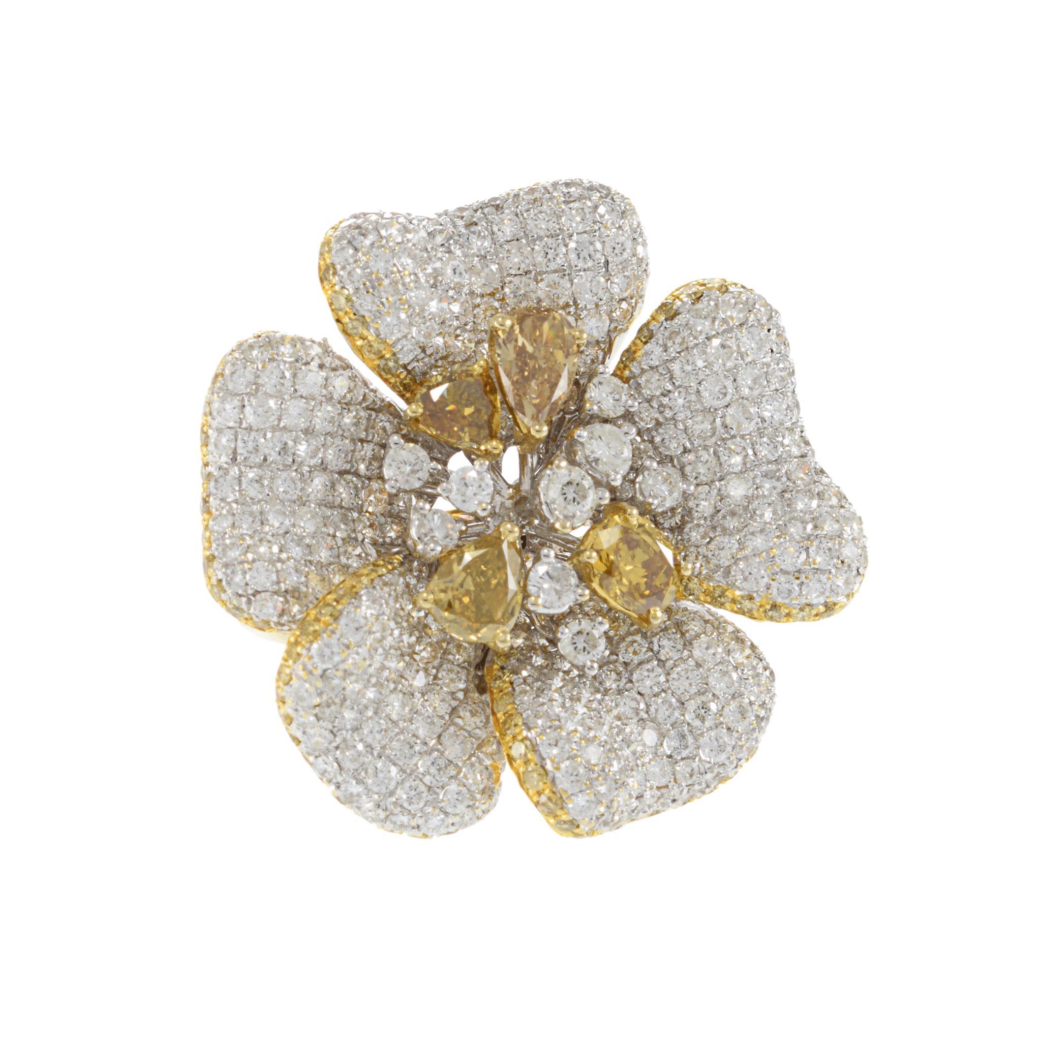 Cette bague exquise est réalisée en or 18 carats et présente un motif floral. Les pétales sont ornés de diamants blancs, totalisant 6,82 carats, d'une pureté VS2 et d'une couleur G. Le centre est orné de diamants jaunes, ajoutant un contraste