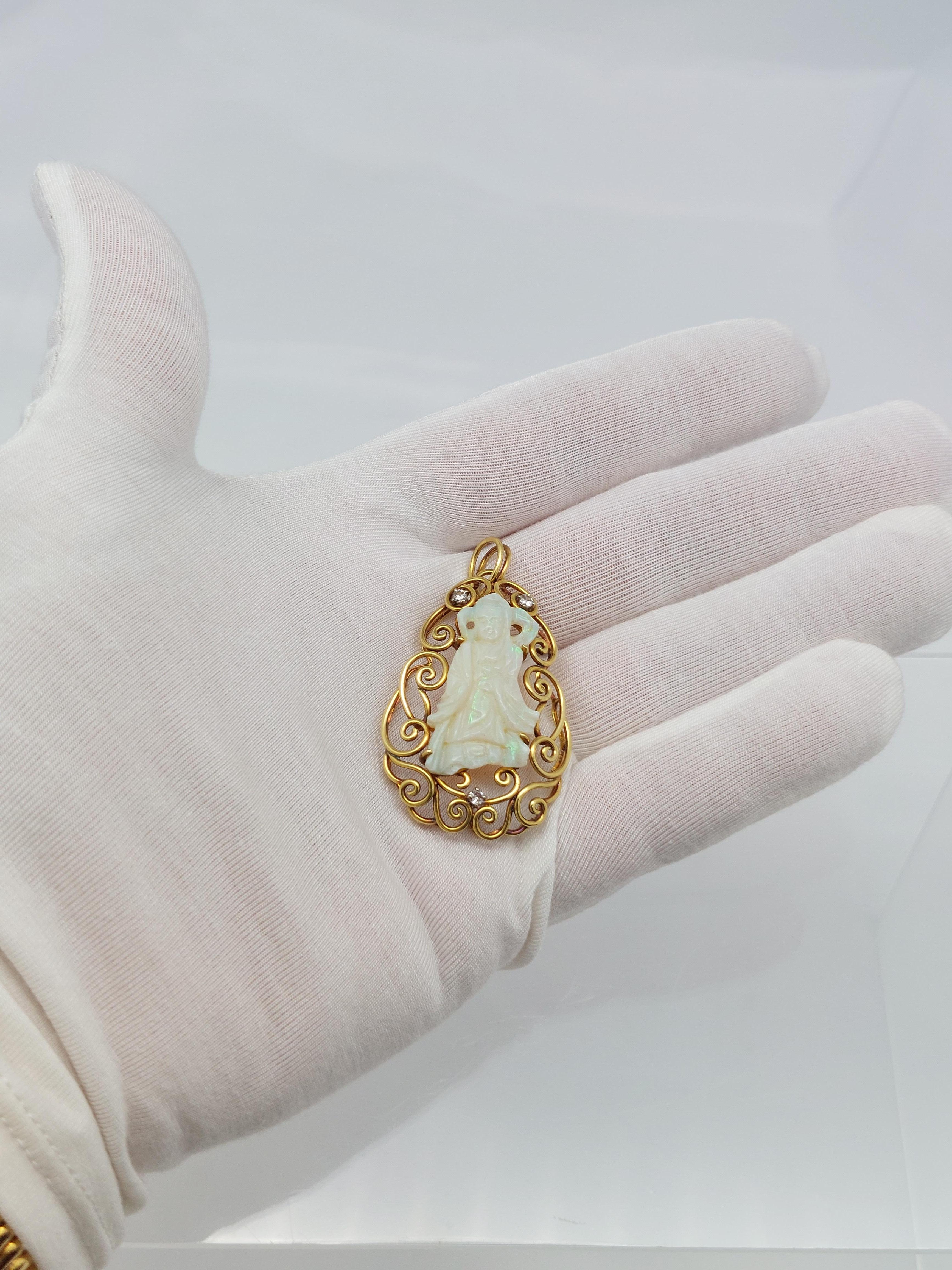 Questo ciondolo unico è realizzato in oro giallo 18 carati.

Al centro delle volute d'oro giallo si trova la figura di una 