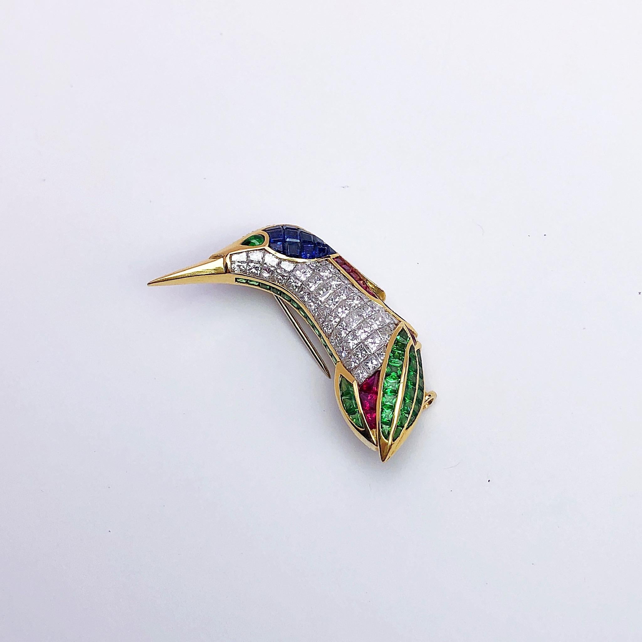 Designed in 18 karat yellow gold , this humming bird brooch is beautifully depicted with gem stones of diamonds, rubies, emeralds and blue sapphires. The combination of the different cut stones including princess, square, round brilliant and