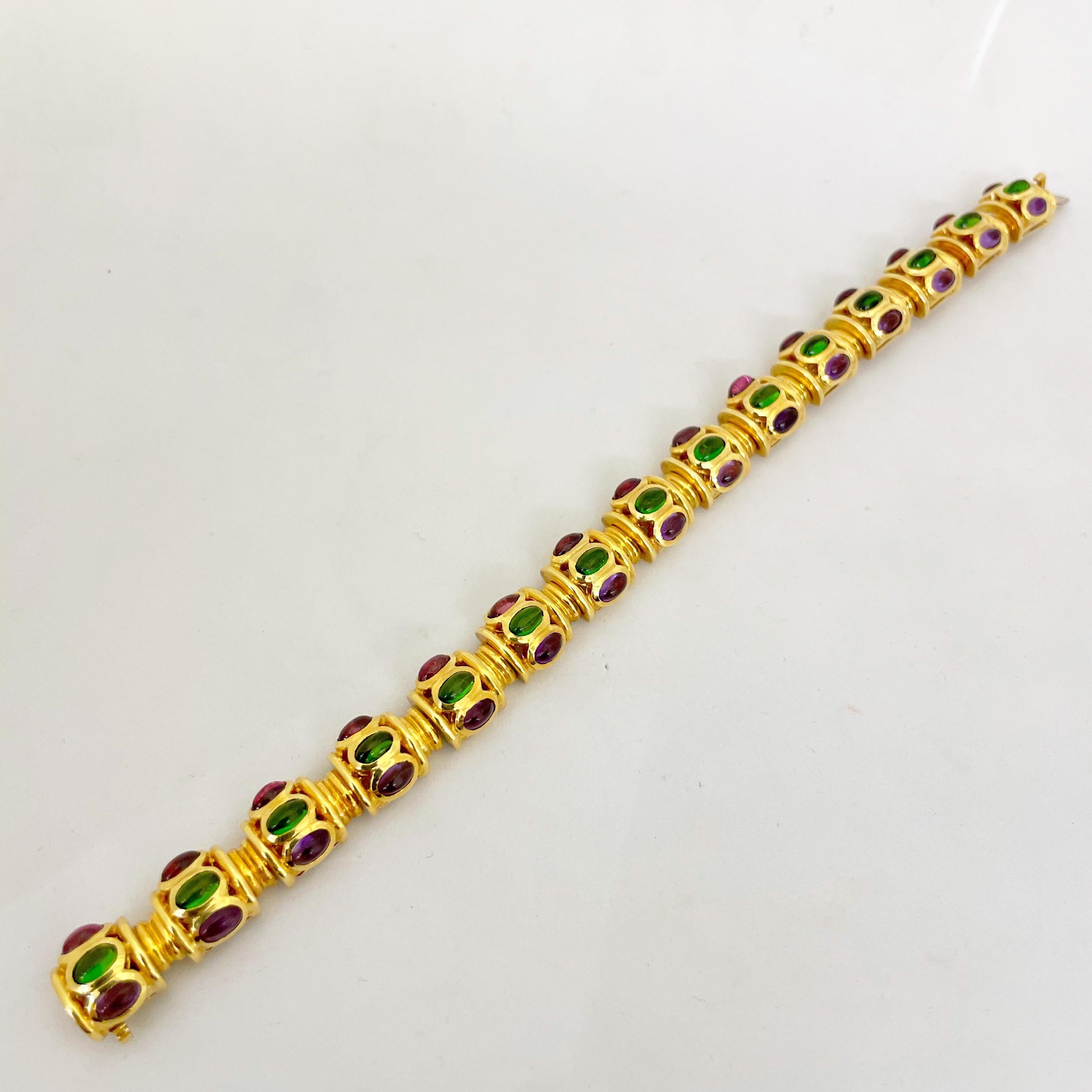 Ein wunderschön gestaltetes Gliederarmband aus 18 Karat Gelbgold. Das Armband besteht aus 15 tonnenförmigen Gliedern, die jeweils mit ovalen Cabochons aus Amethyst, Diopsid und Rhodoit besetzt sind. Wenn das 7-1/8