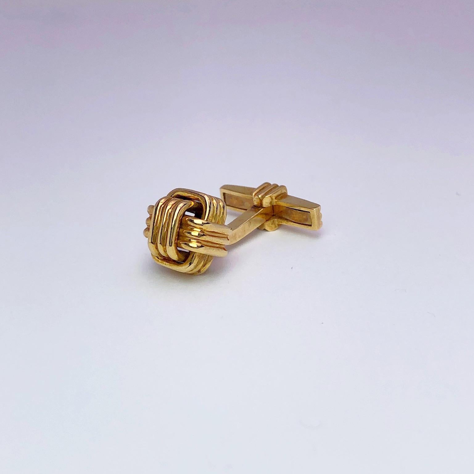 Classic 18 karat yellow gold knot cufflinks designed with a monkey's fist knot and a collapsible back.
