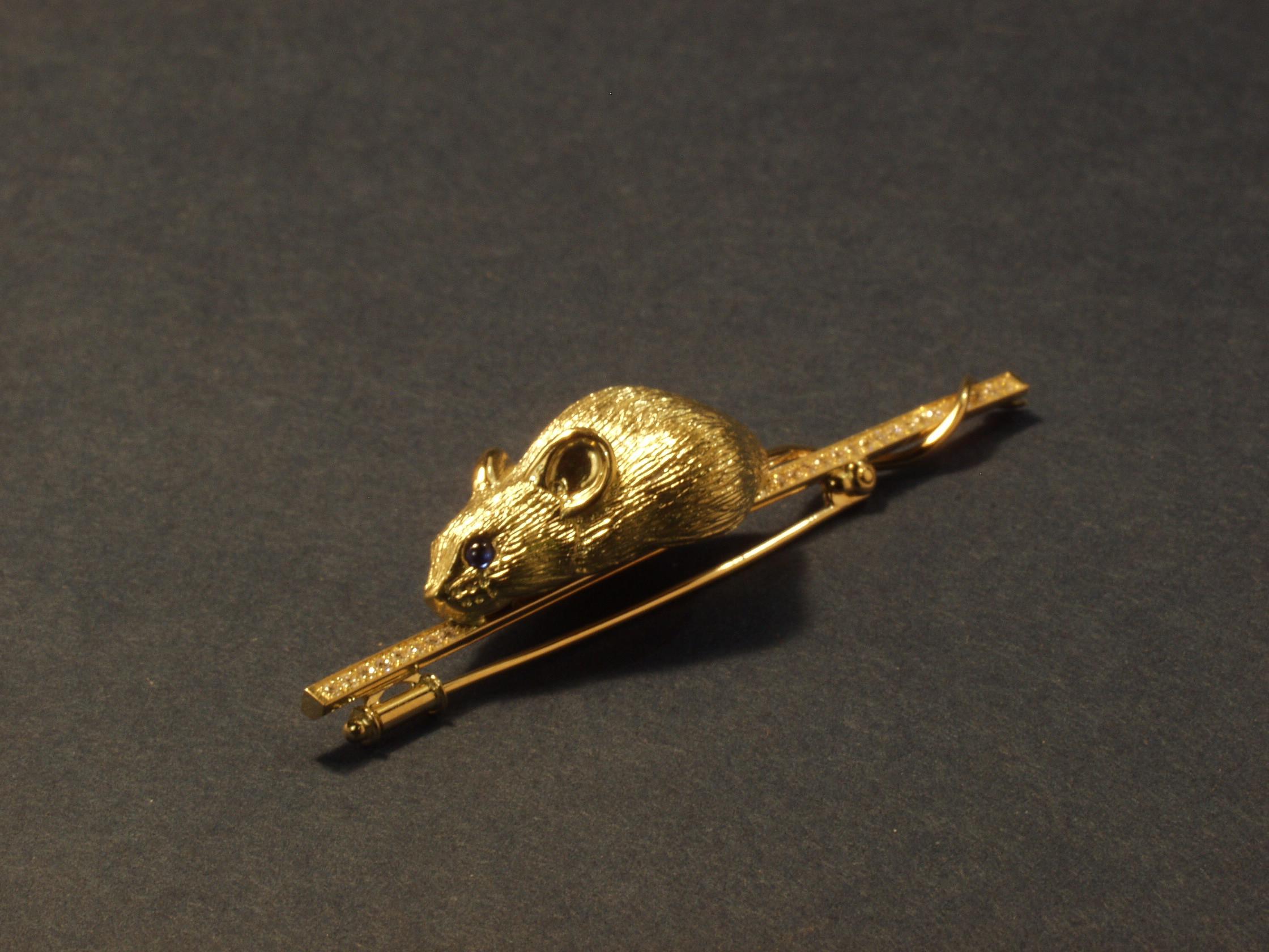 This 18kt Yellow Gold Mouse Brooch is set with Sapphire eyes and 50 Diamonds.