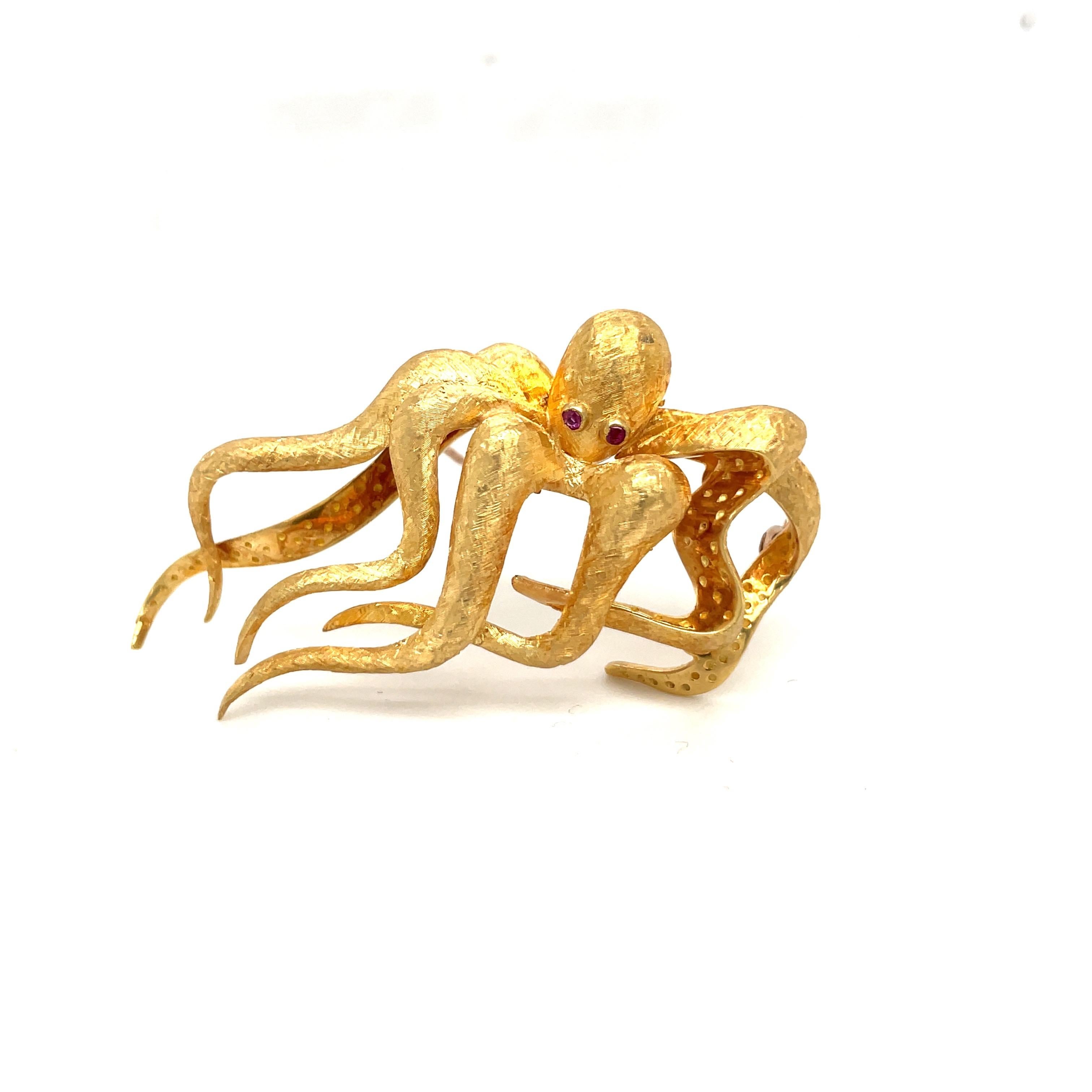 Oktopus-Brosche aus 18 Karat Gelbgold. Der Oktopus ist in einer matten Ausführung mit eingefassten Rubinaugen gefertigt. Er misst 2