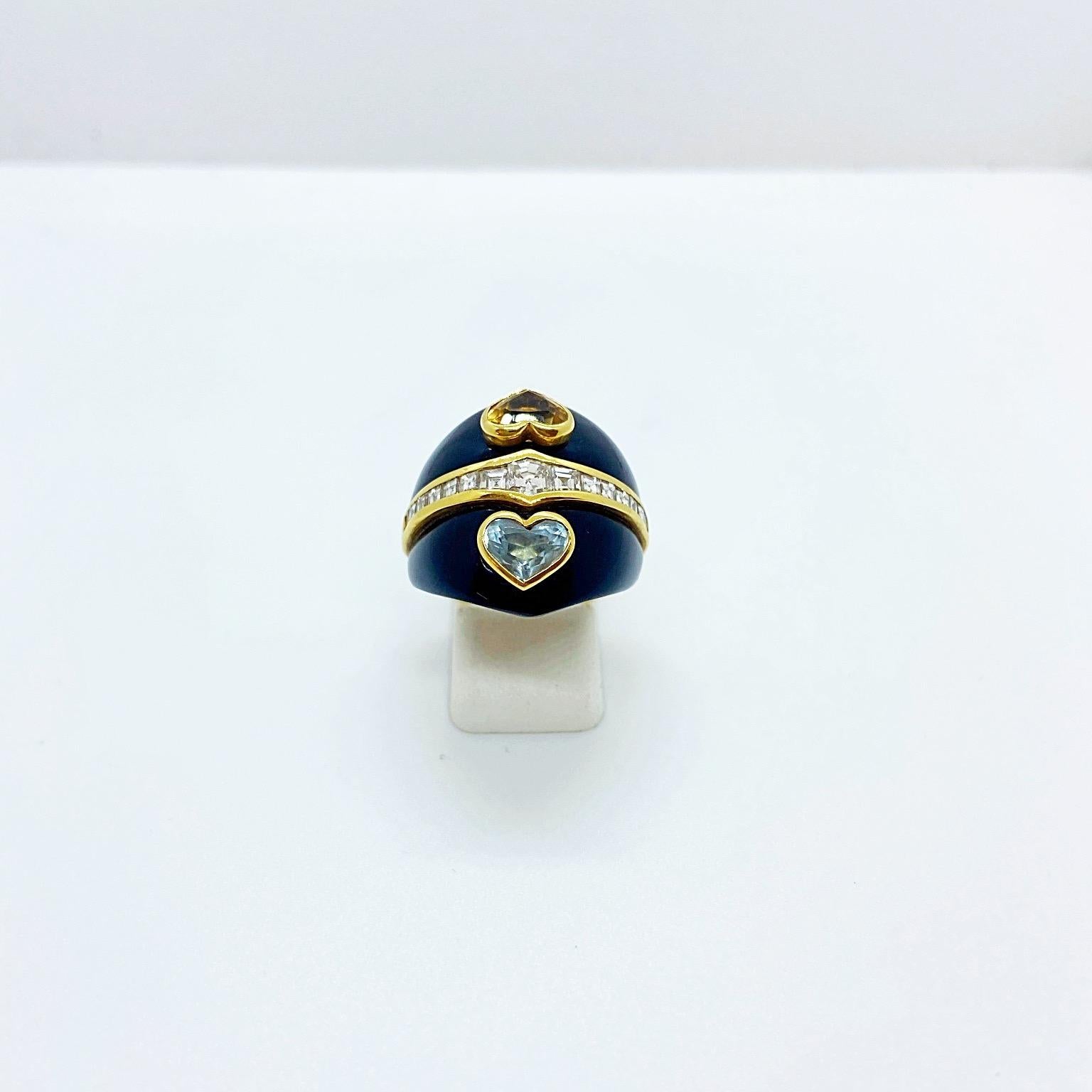 A beautifully crafted 18 karat yellow gold dome shaped ring. Two sections of black onyx are equally divided with a row of square cut diamonds. Two bezel set hearts ,one in citrine, the other in aquamarine are mounted atop the onyx. The color