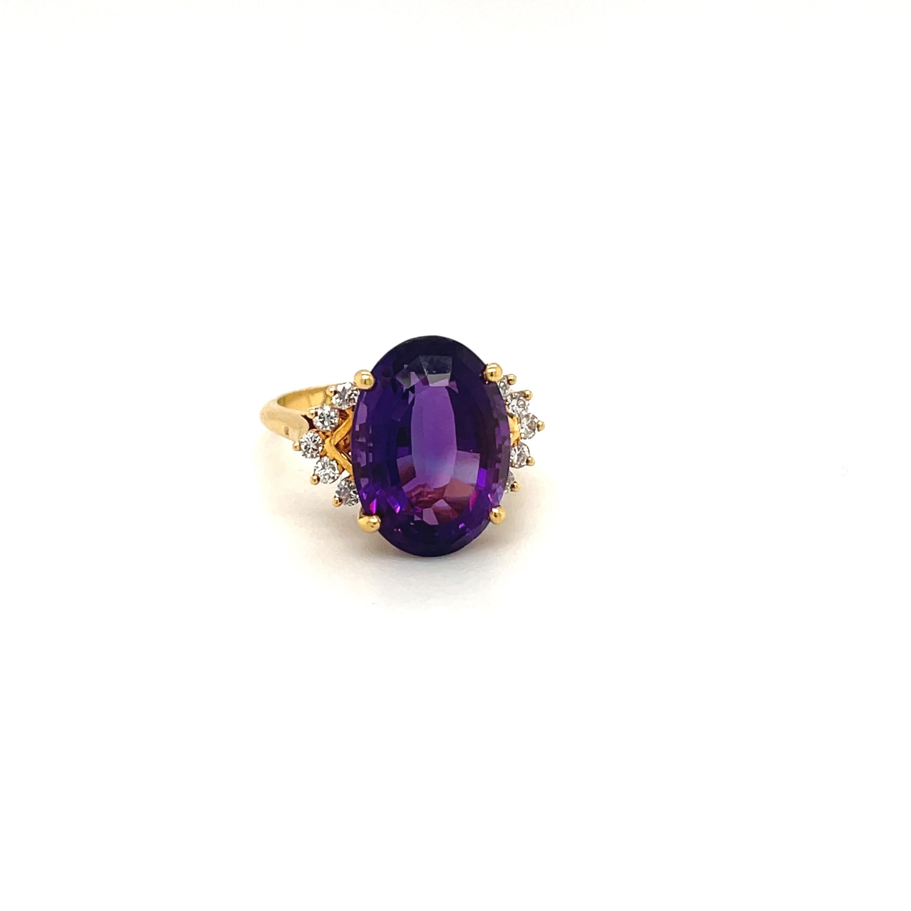 Classic 18 karat yellow gold ring set with a beautiful intense oval amethyst center. The large oval is flanked by 10 round brilliant diamonds. 
Amethyst 7.24 carats
Diamonds 0.76 carats
Stamped 18K with the jewelers hallmark
Ring size 8.25 sizing
