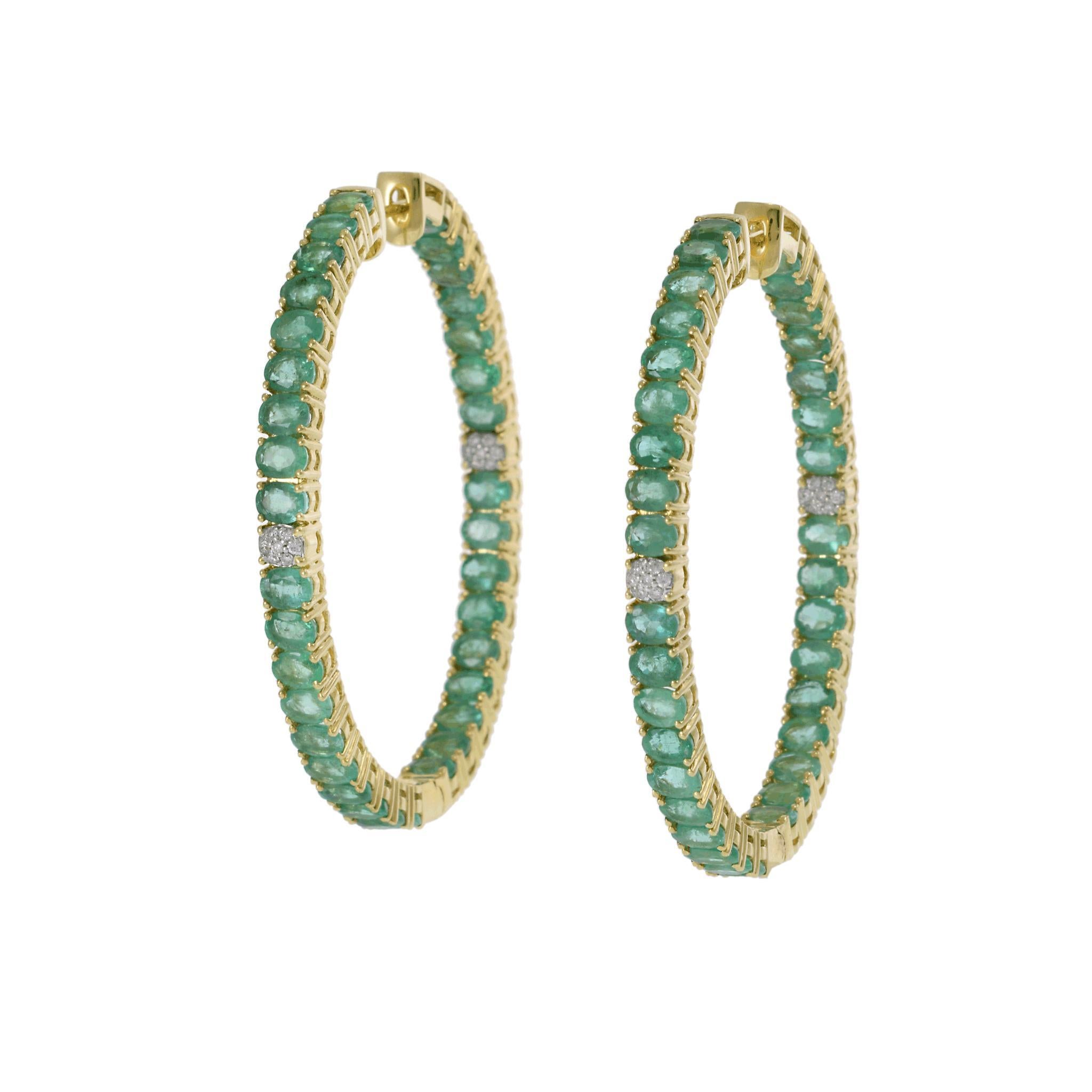 A bold and vibrant pair of 18KT yellow gold hoop earrings, crafted in an in-and-out oval design and set with 12.25CT-TW of rich green oval-cut emeralds. Accentuating the lush emeralds are 0.14CT-TW of round-cut diamonds, adding brilliance and