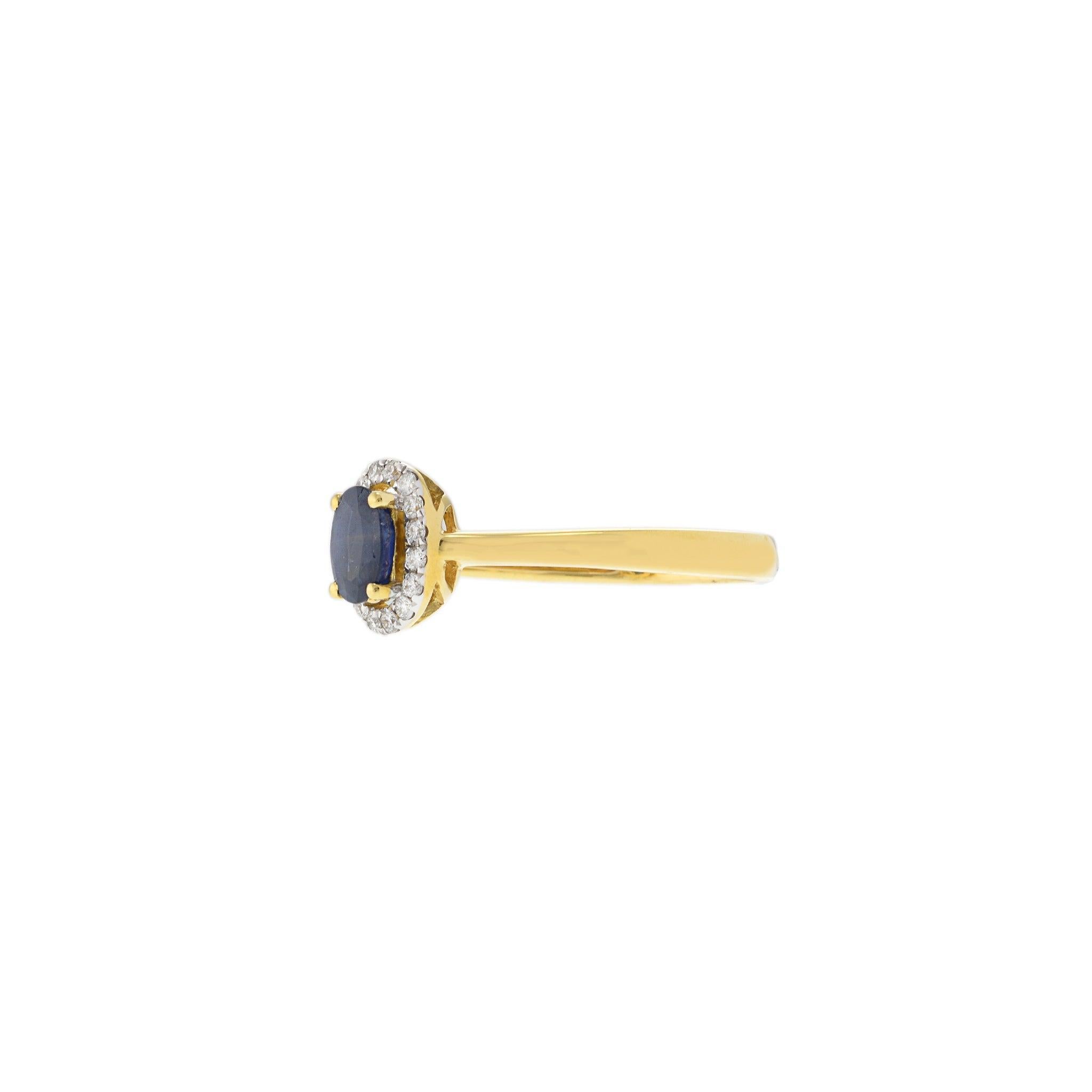 Un luxe discret définit cette bague raffinée en or jaune 18KT, centrée sur un riche saphir bleu de taille ovale entouré d'un délicat halo de diamants ronds étincelants. L'éclat chaud de l'or jaune contraste magnifiquement avec la brillance froide du