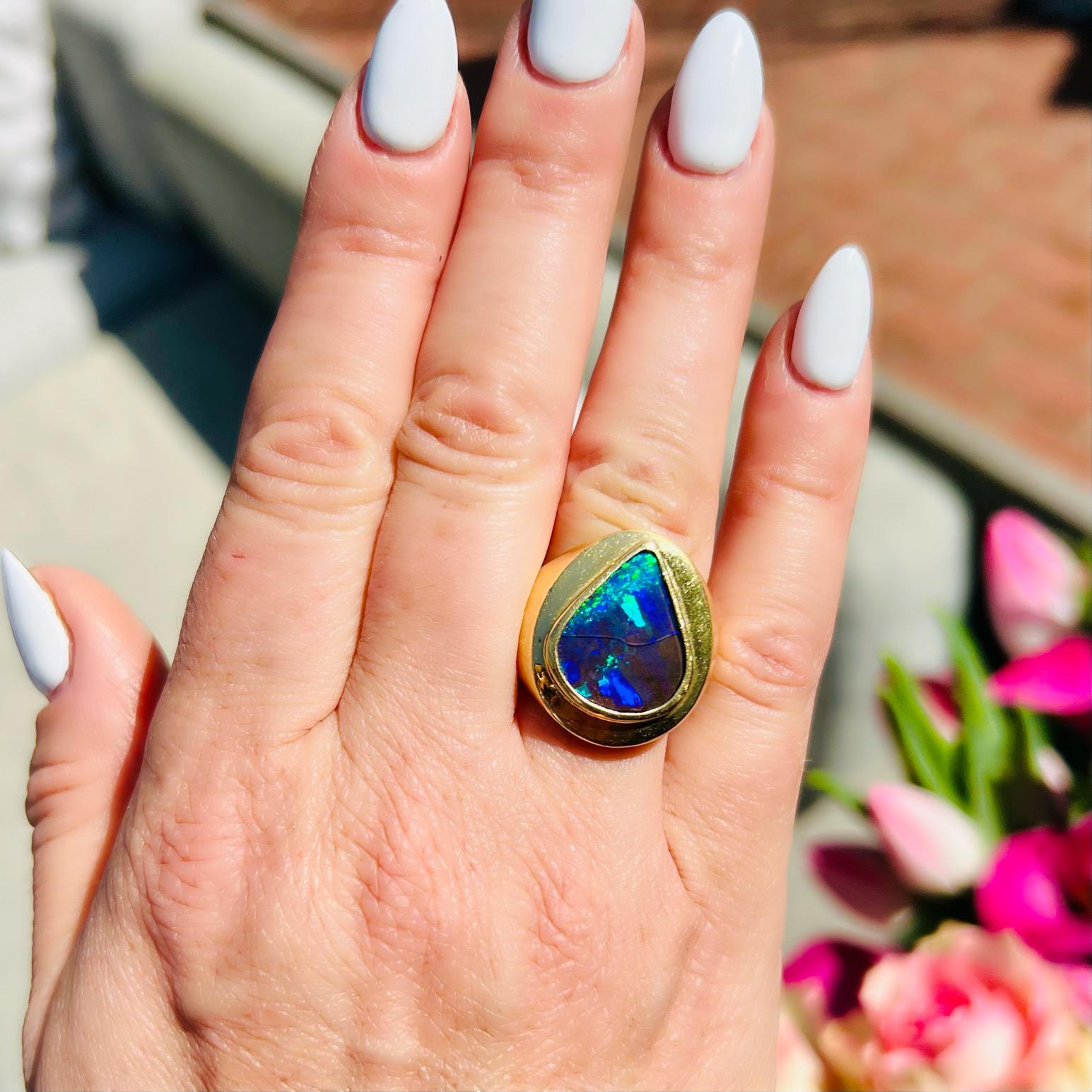Deep blues and rich greens permeate this gorgeous estate ring, making it stand out from the rest. The Australian boulder opal makes you want to sink into the rich pools of peacock tones. The 18kt yellow gold estate ring weighs a significant 24.5