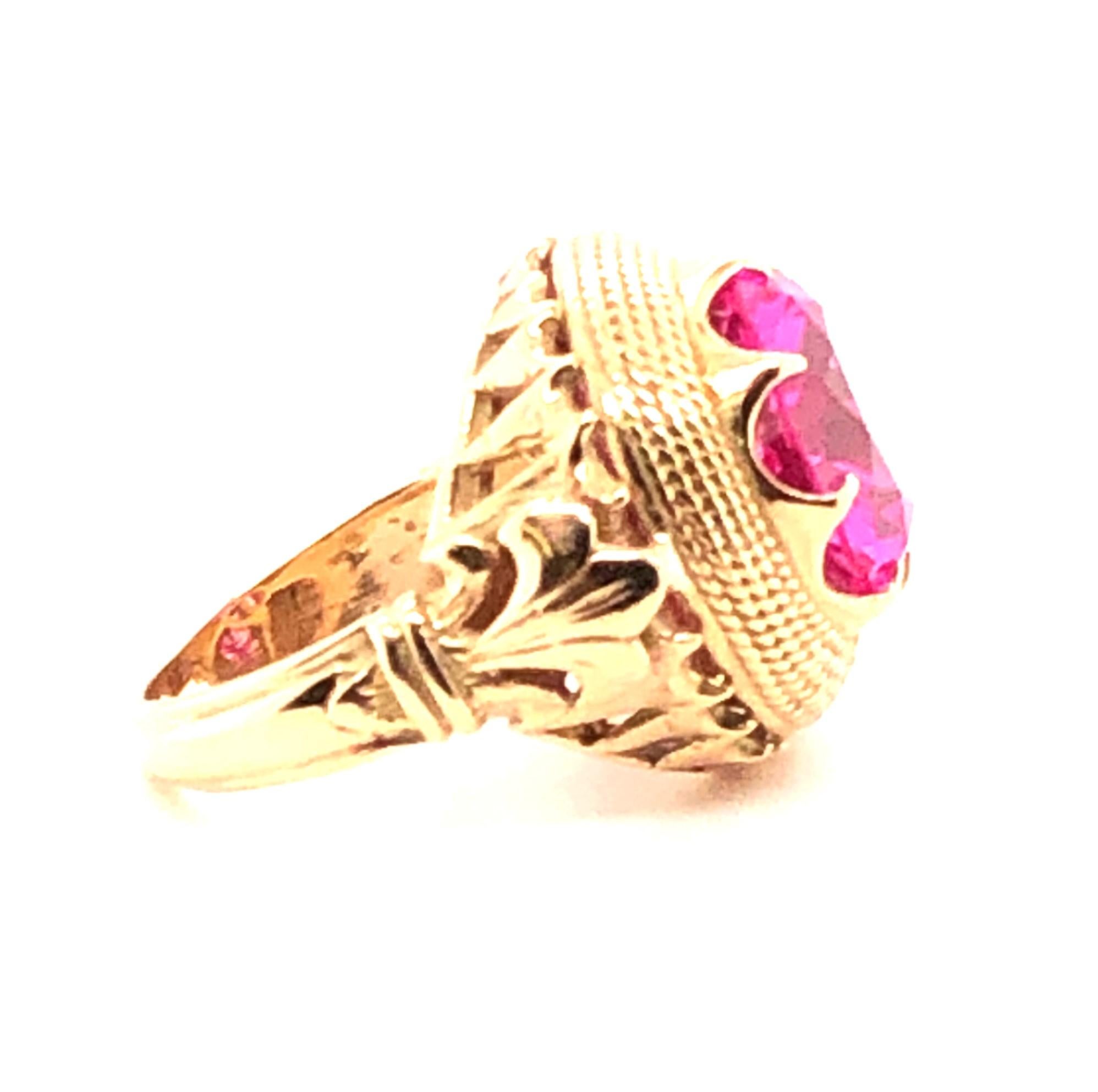 This is a statement ring! The whole ring is crafted in 18kt yellow gold with two Fleur De Lis on each side. The center of the ring contains one round brilliant cut 15.50 carat HOT PINK synthetic sapphire. This ring is a finger size 7.50 and can be