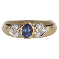 Anillo de oro amarillo de 18 quilates con zafiro cabujón y corazones de diamantes