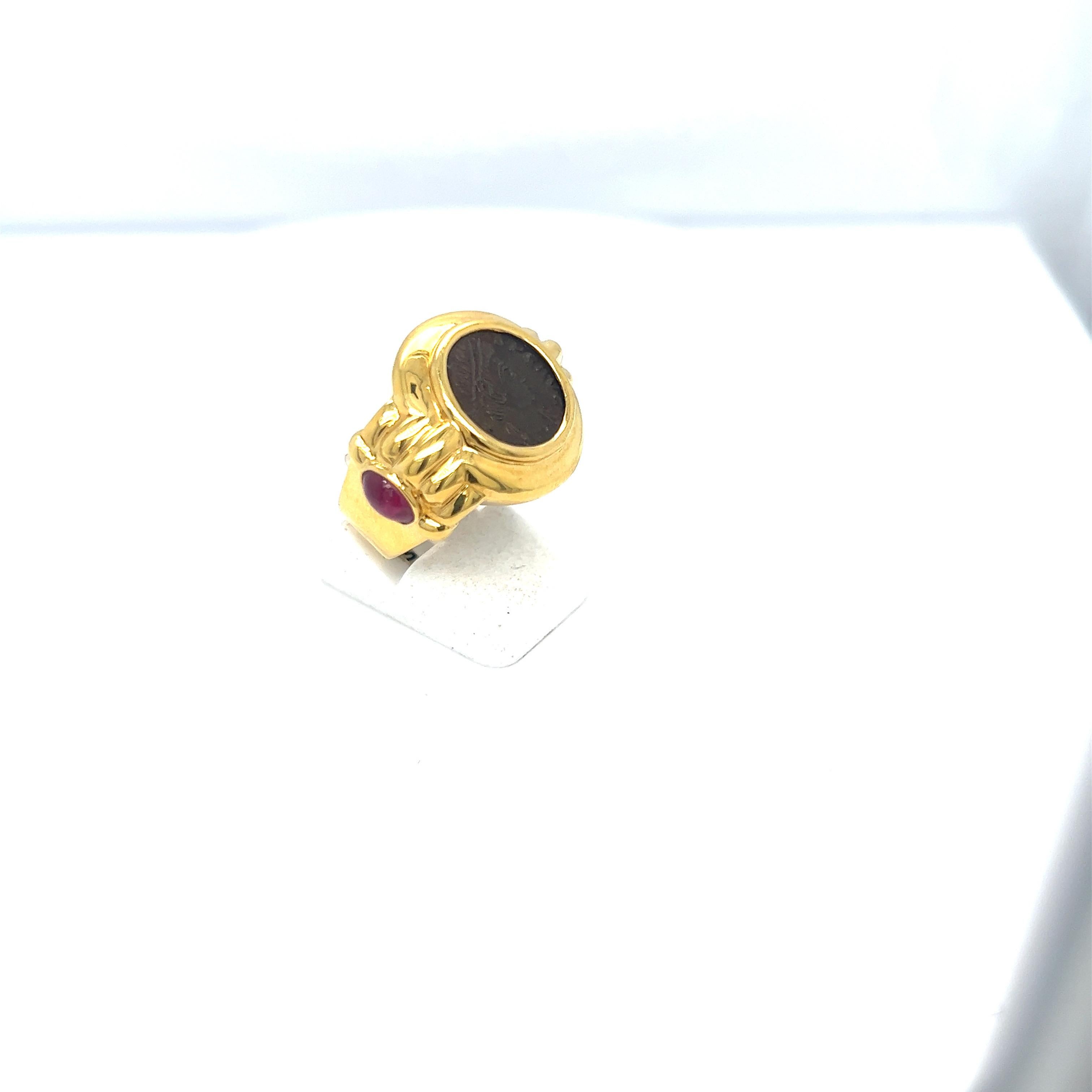 Vintage 18 karat yellow gold ring set with a blackened coin .The sides of the ring are set with oval cabochon rubies.
Stamped 750 18 k
Ring size 6.5