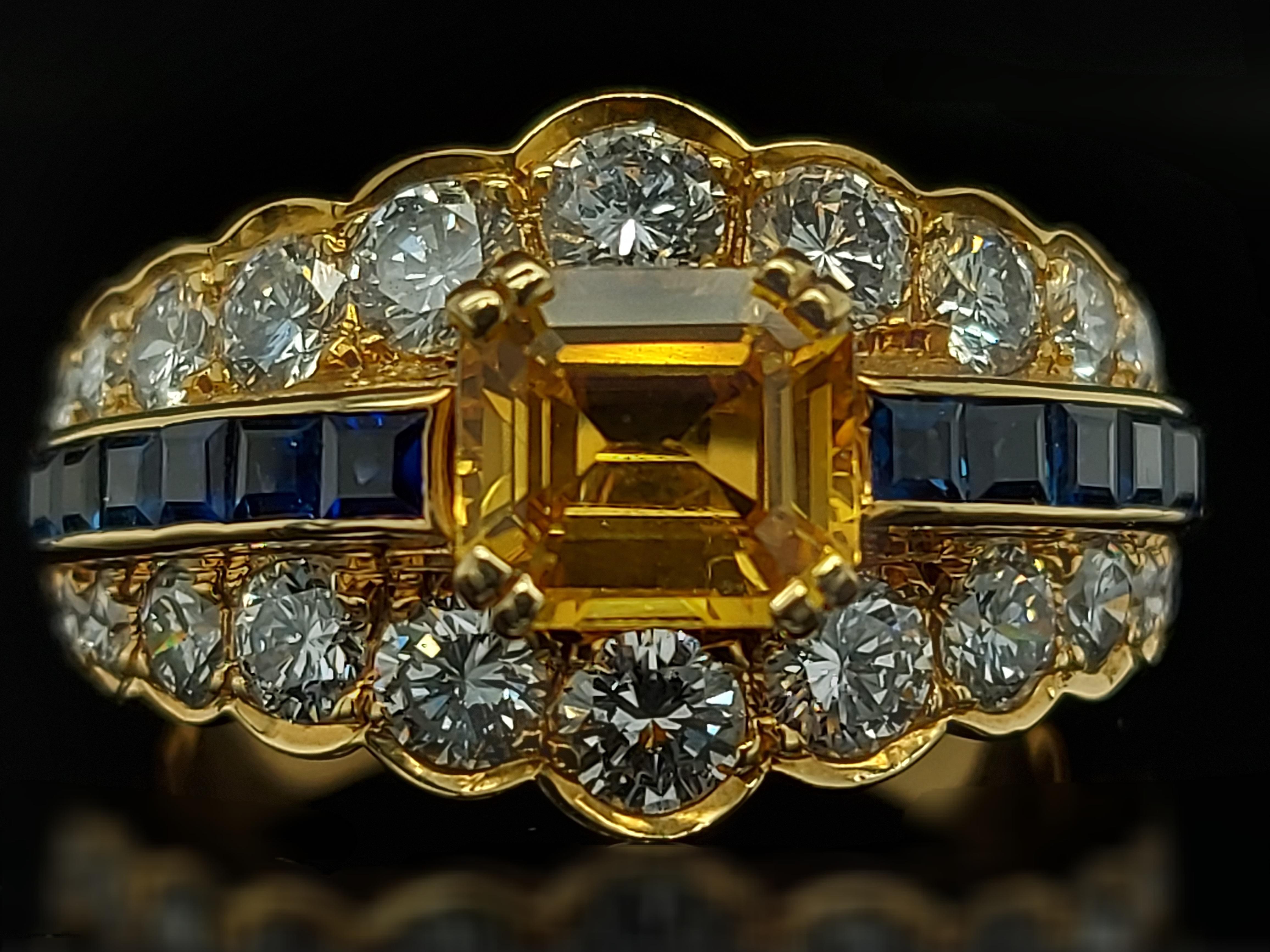 Magnifique bague en or jaune de 18kt avec grand saphir jaune, saphirs bleus et diamants.

Saphir : 12 petits saphirs bleus de taille princesse et un grand saphir jaune de taille émeraude d'environ 50 cts. 1.50 cts

Diamants : 24 diamants taille