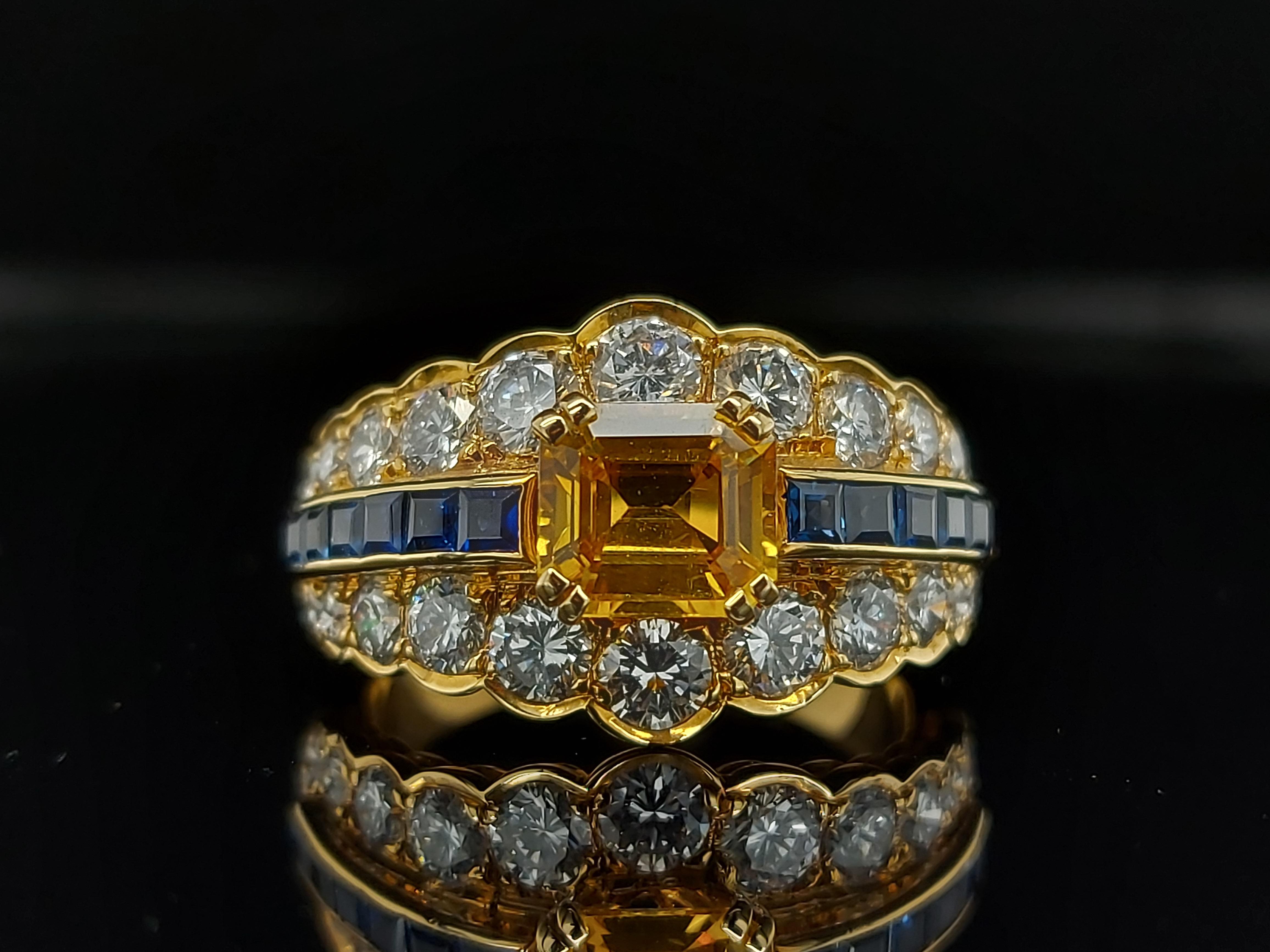 Emerald Cut 18 Karat Yellow Gold Ring with Large Yellow Sapphire Blue Sapphires and Diamonds For Sale