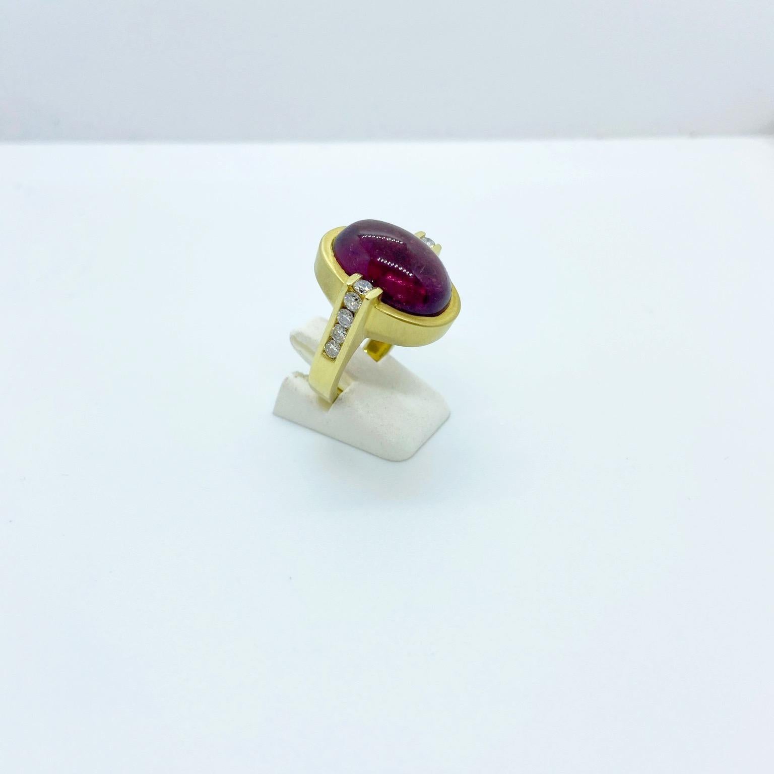 The centerpiece of this ring is the large oval rubelite stone. The 18 karat yellow gold setting is a combination of a matte and shiny finish. Ten round brilliant diamonds 0.65 carats accent the center stone.
Ring size 6  sizing options may be