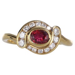 Anello in oro giallo 18 carati con rubino ovale e pavé di diamanti