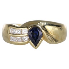 Anillo de oro amarillo de 18 quilates con zafiro talla pera y diamantes baguette