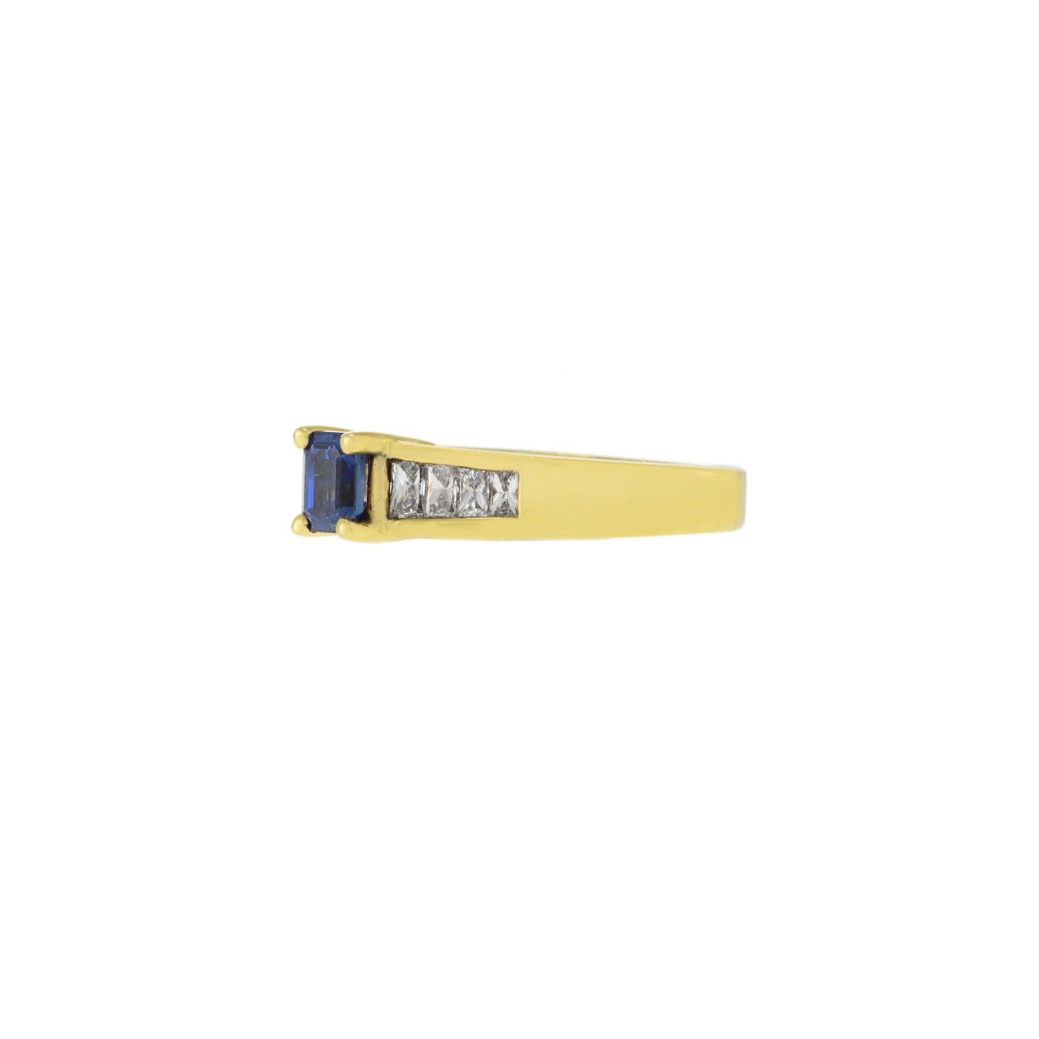 Elaborado en rico oro amarillo de 18 quilates, este elegante anillo tiene como piedra central un vívido zafiro talla esmeralda de 0,55 quilates. A lo largo de la banda hay brillantes diamantes talla magnate de 0,45 quilates, certificados G-VVS por