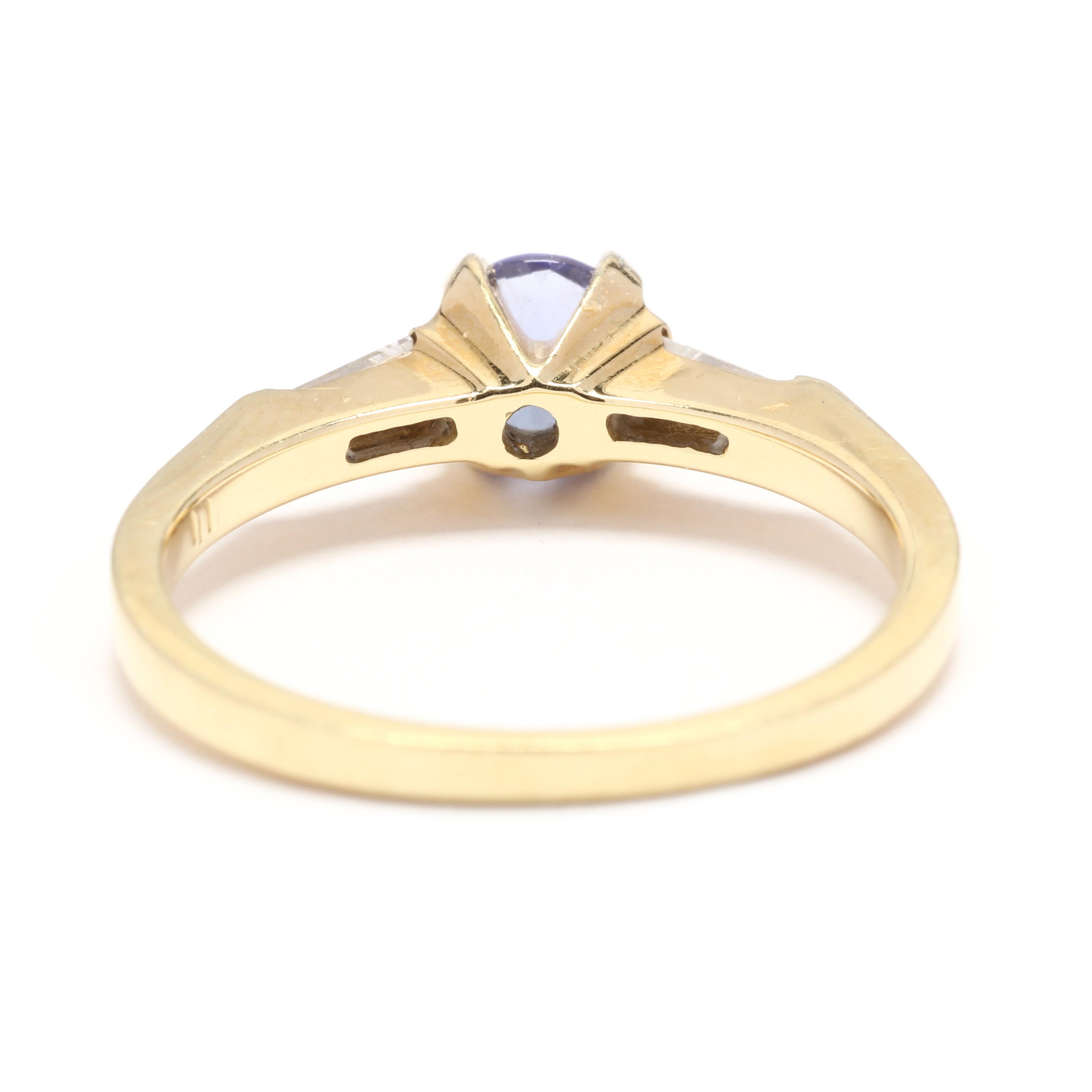 A vintage 18 karat yellow gold sapphire and diamond ring. This three stone ring features a prong set round cut sapphire weighing approximately .60 carat with a tapered baguette cut diamond on either side weighing approximately .16 total carats and a